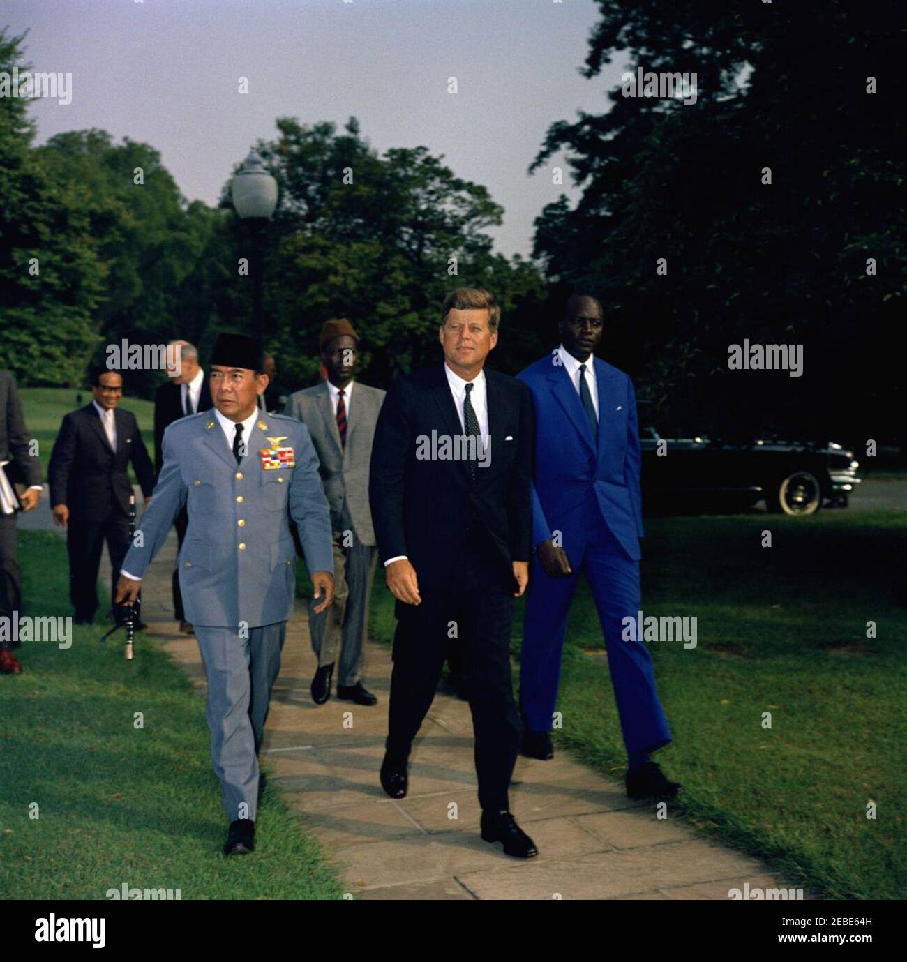 Rencontre avec Sukarno, Président de l'Indonésie, et Modibo Keu00efta, Président du Mali, 4 h 05. Le Président John F. Kennedy marche avec les représentants de la Conférence de Belgrade des nations non alignées sur la pelouse sud de la Maison Blanche, Washington, D.C., à gauche se trouve le Président Ahmed Sukarno de l'Indonésie (uniforme militaire); à droite du Président Kennedy est le Président Modibo Keu00efta du Mali (costume bleu). Le secrétaire d'État Dean Rusk marche en arrière-plan avec le ministre indonésien des Affaires étrangères, M. Subandrio. Banque D'Images