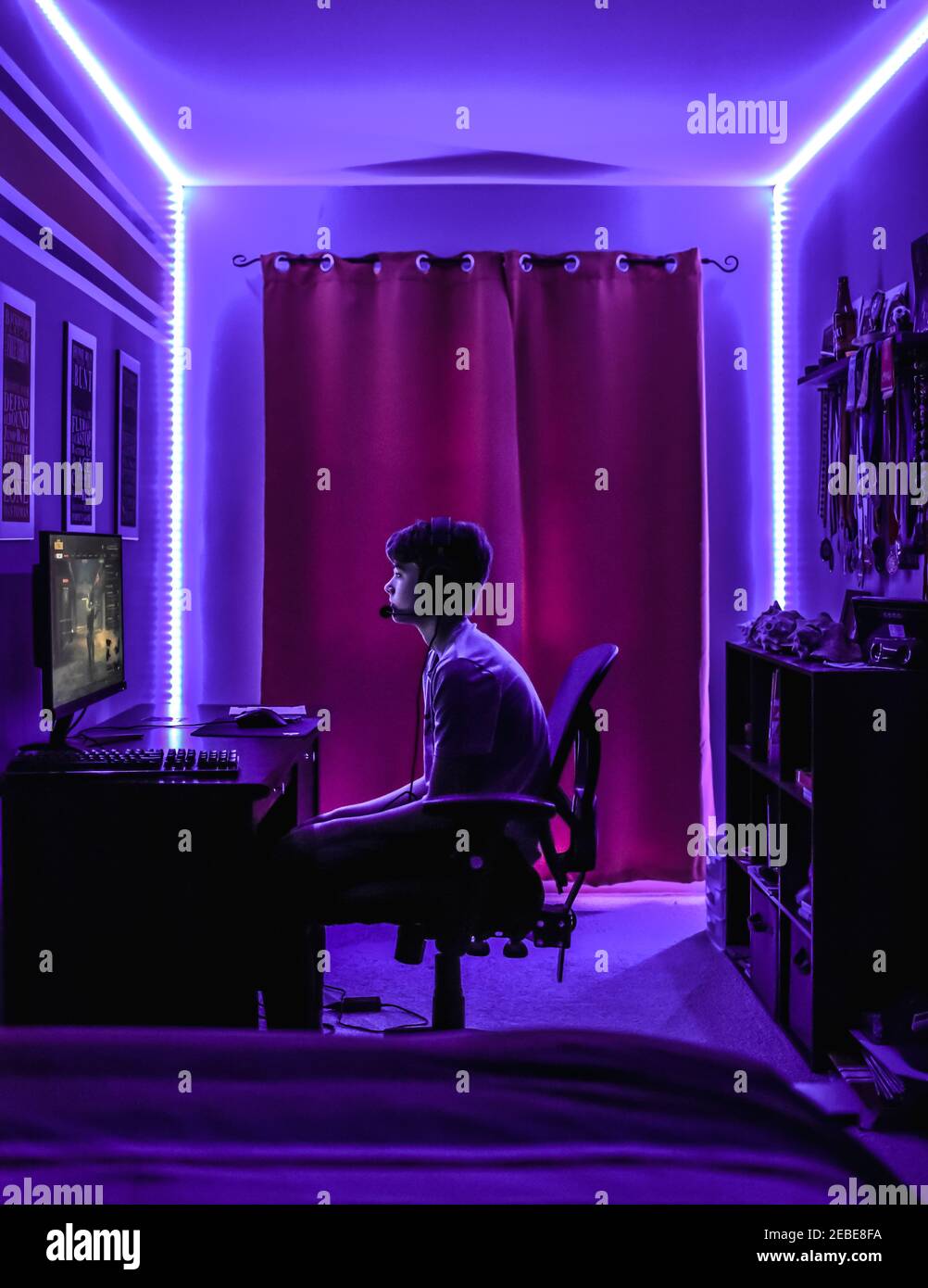 Adolescent jouant à un jeu vidéo au bureau dans la chambre avec éclairage  LED au néon Photo Stock - Alamy