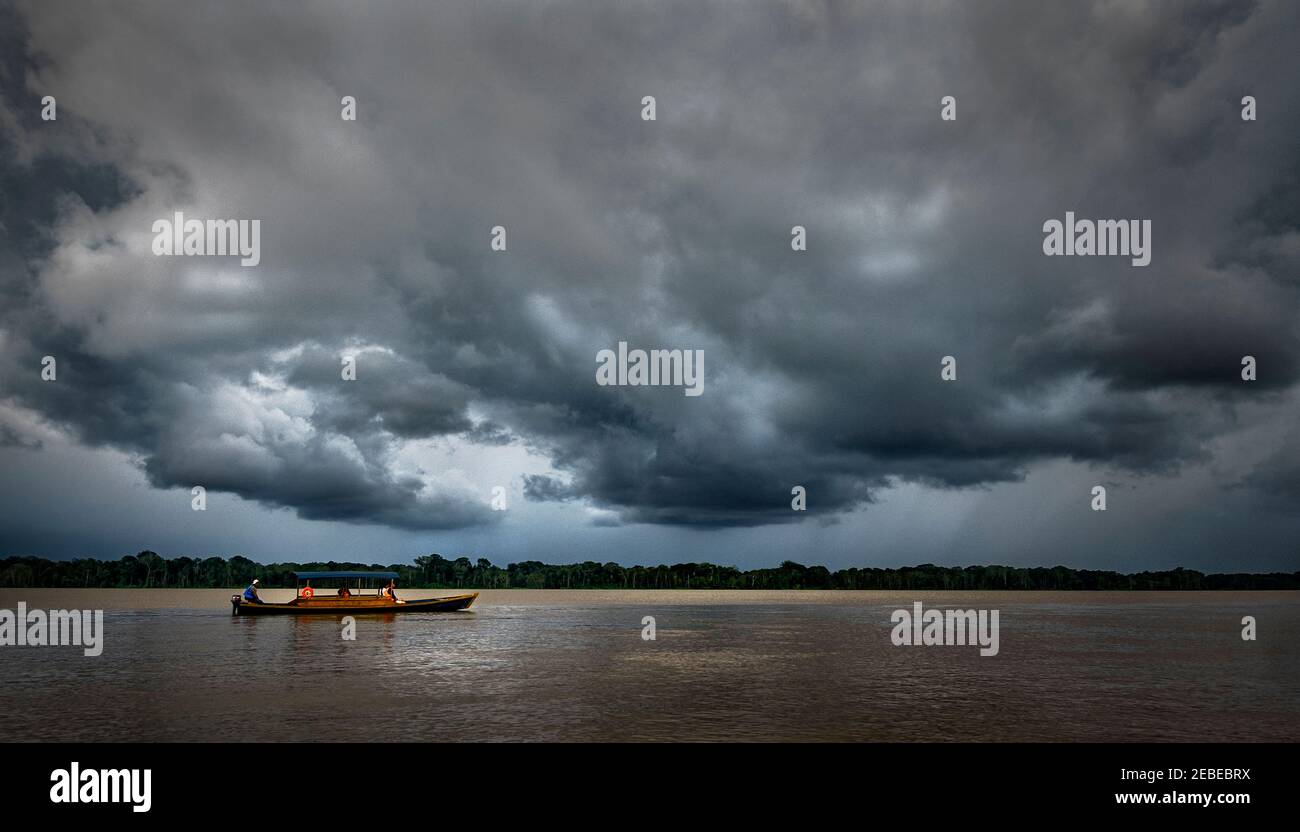Un bateau descend la rivière Amazone à l'approche d'une tempête près de Mocagua, Amazonas, Colombie. Banque D'Images