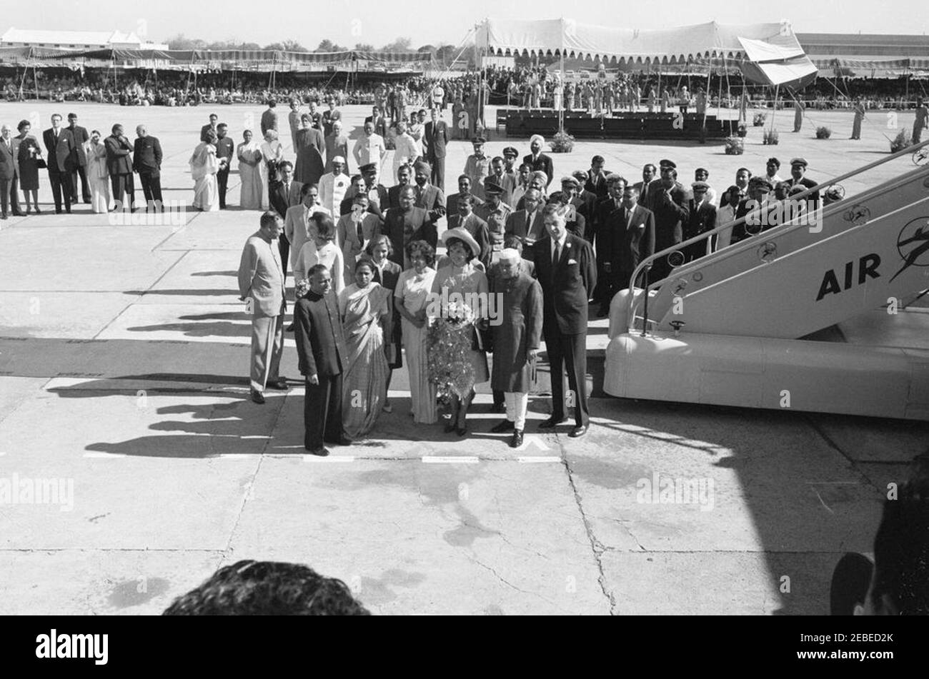 Première dame Jacqueline Kennedyu2019s (JBK) voyage en Inde et au Pakistan: New Delhi, Delhi, Inde, arrivée. La première dame Jacqueline Kennedy arrive à l'aéroport de Palam à New Delhi, en Inde. Debout devant le tapis, de gauche à droite: Ambassadeur indien aux États-Unis, B. K. Nehru; princesse Lee Radziwill de Pologne, sœur de Mme Kennedy; deux personnes non identifiées devant; Kitty Galbraith, épouse de l'ambassadeur des États-Unis en Inde; Indira Gandhi, fille du Premier ministre de l'Inde; Mme Kennedy; Premier ministre de l'Inde, Jawaharlal Nehru; ambassadeur des États-Unis en Inde, John Kenneth Galbraith. Banque D'Images