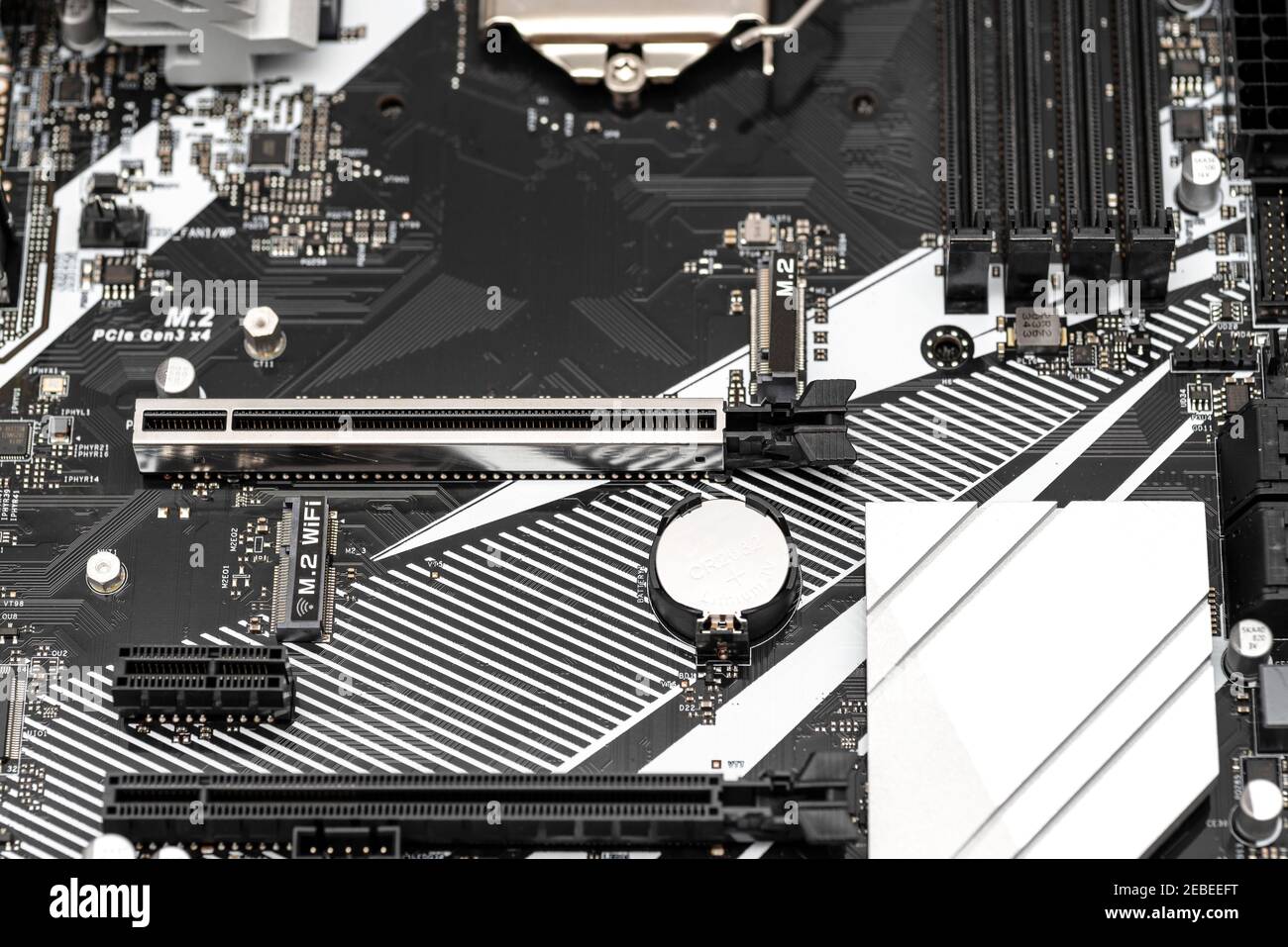 Carte mère moderne d'un ordinateur de bureau de couleur noire avec connecteur PCI Express visible, batterie et dissipateurs thermiques. Banque D'Images
