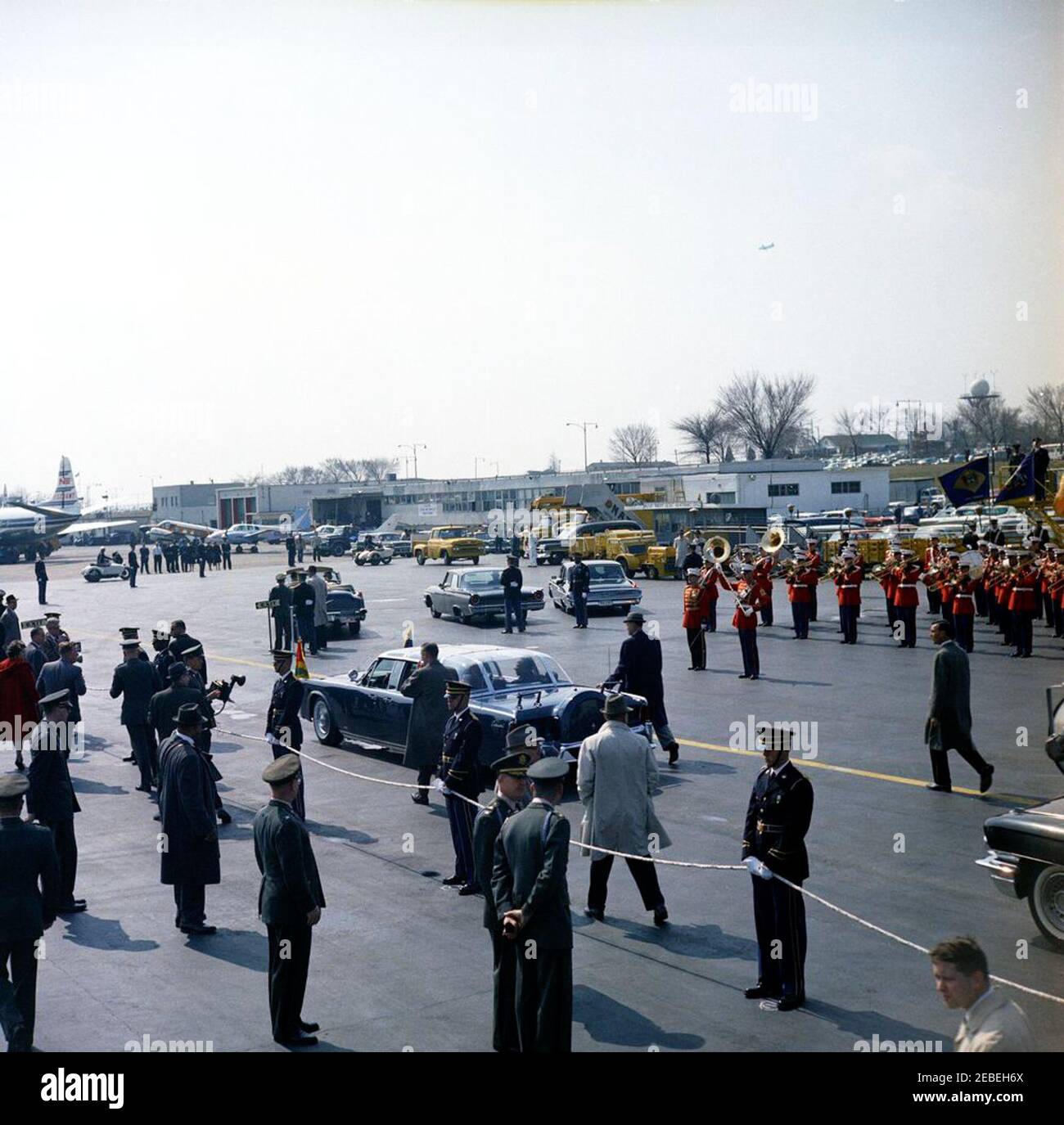 Cérémonie d'arrivée à Sylvanus Olympio, Président du Togo, 11 h 00. Une limousine bubbletop, transportant le président John F. Kennedy et le président Sylvanus Olympio du Togo, traverse le terminal du service militaire de transport aérien (MAT) de l'aéroport national de Washington, après les cérémonies d'arrivée du président Olympio. Sont également photographiés Sam Sulliman, Roy Kellerman et Bob Lilley, agents du Service secret de la Maison Blanche. LE US Marine Band joue en arrière-plan. Washington, D.C. Banque D'Images