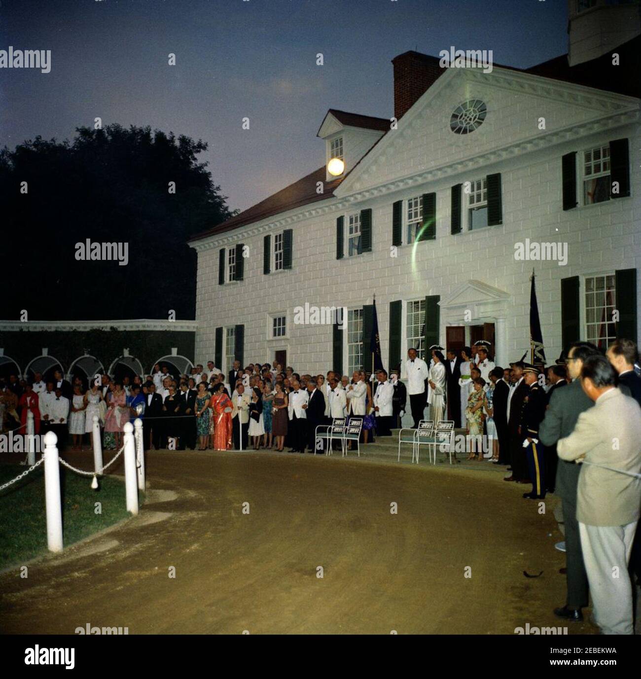 Dîner à Mount Vernon en l'honneur de Muhammad Ayub Khan, président du Pakistan, 7:45. Dîner d'Etat en l'honneur du Président du Pakistan, Mohammad Ayub Khan. (R u2013): Président Mohammad Ayub Khan; Begum Nasir Akhtar Aurangzeb, fille du président Ayub Khan; président John F. Kennedy; première dame Jacqueline Kennedy; aide navale au président Commandant Tazewell Shepard, Jr. Secrétaire d'État Dean Rusk (à gauche des escaliers); Secrétaire social de la première Dame Letitia Baldrige (derrière le secrétaire Rusk, portant une robe fleurie mauve); aide de la Force aérienne au président général de brigade Godfrey T. McHugh ( Banque D'Images