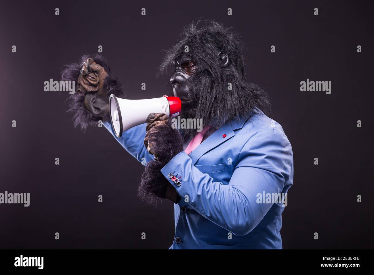 homme d'affaires portant un masque de gorille et criant à megafon Banque D'Images