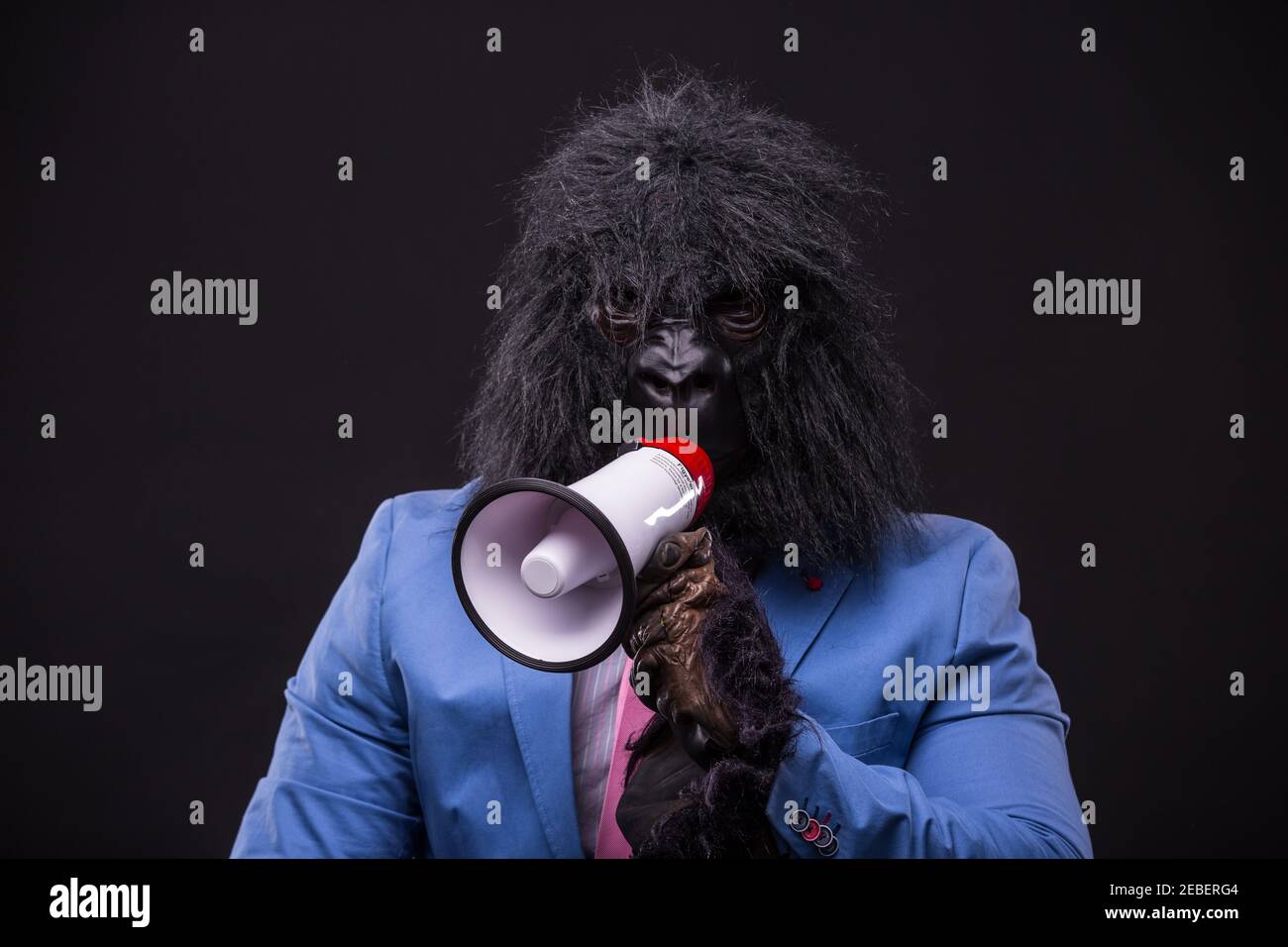 homme d'affaires portant un masque de gorille et criant à megafon Banque D'Images