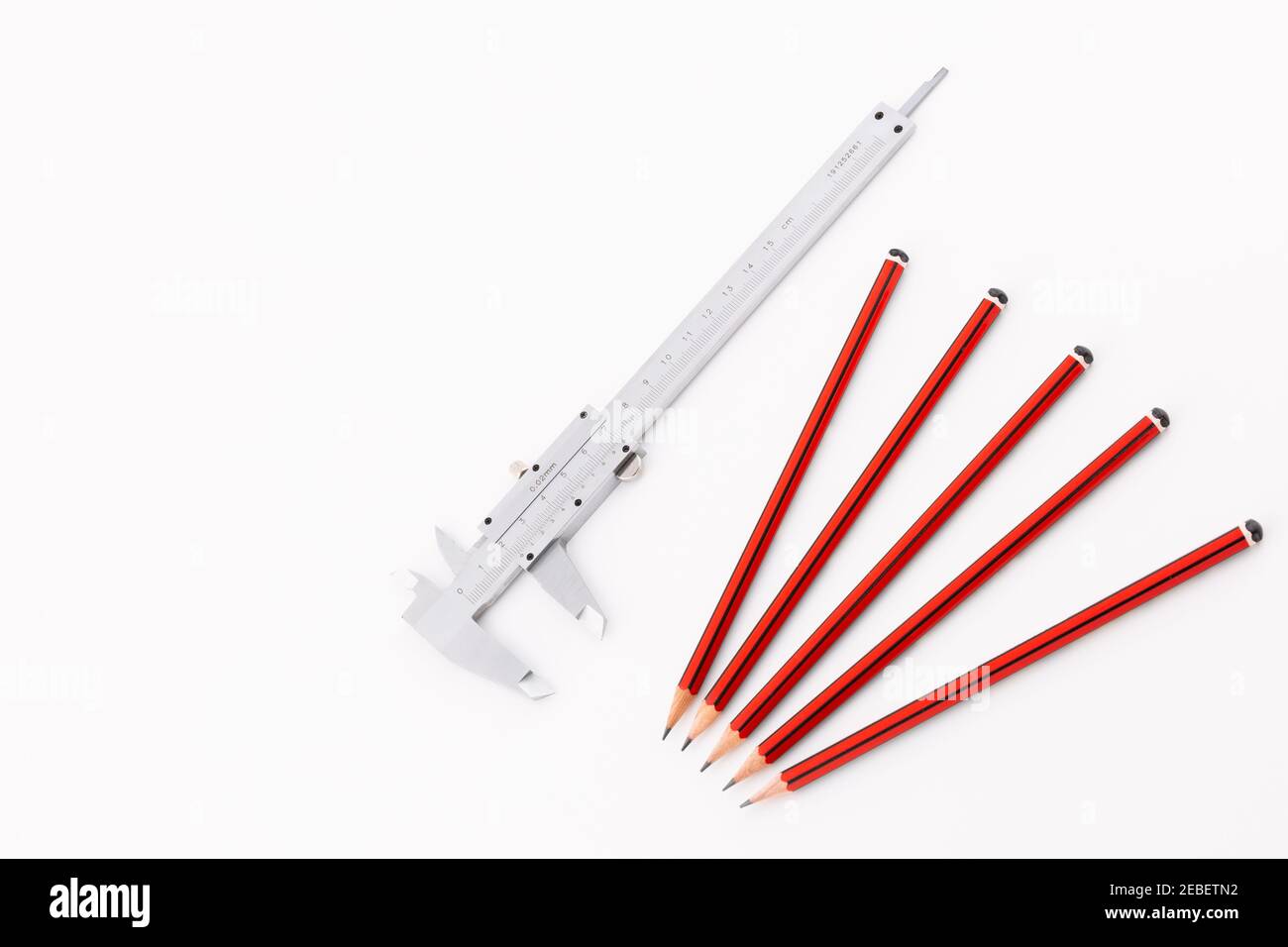 Pied à coulisse analogique avec groupe de cinq crayons isolés Arrière-plan blanc Banque D'Images
