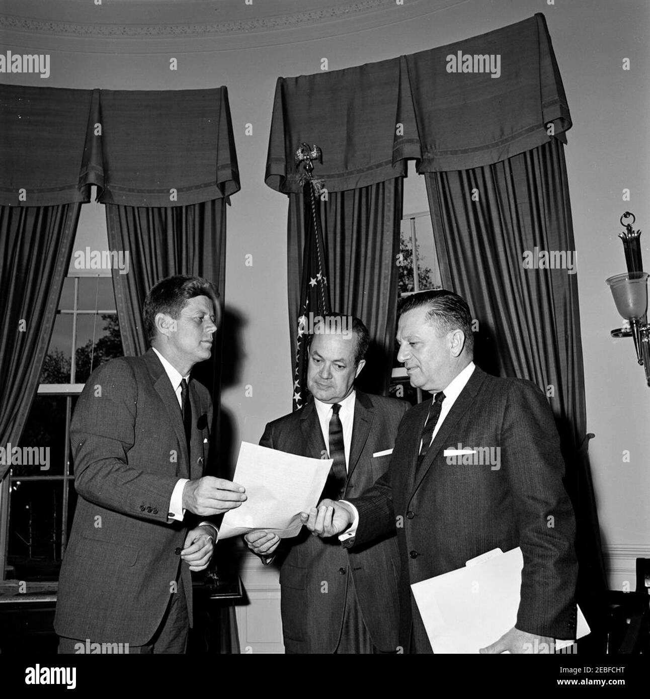 Rencontre avec les sénateurs Alan H. Bible et Howard W. Cannon (Nevada), 5 h 52. Le Président John F. Kennedy rencontre le sénateur Alan Bible (au centre) du Nevada et le sénateur Howard W. Cannon (à droite) du Nevada dans le Bureau ovale, Maison Blanche, Washington, D.C. Banque D'Images