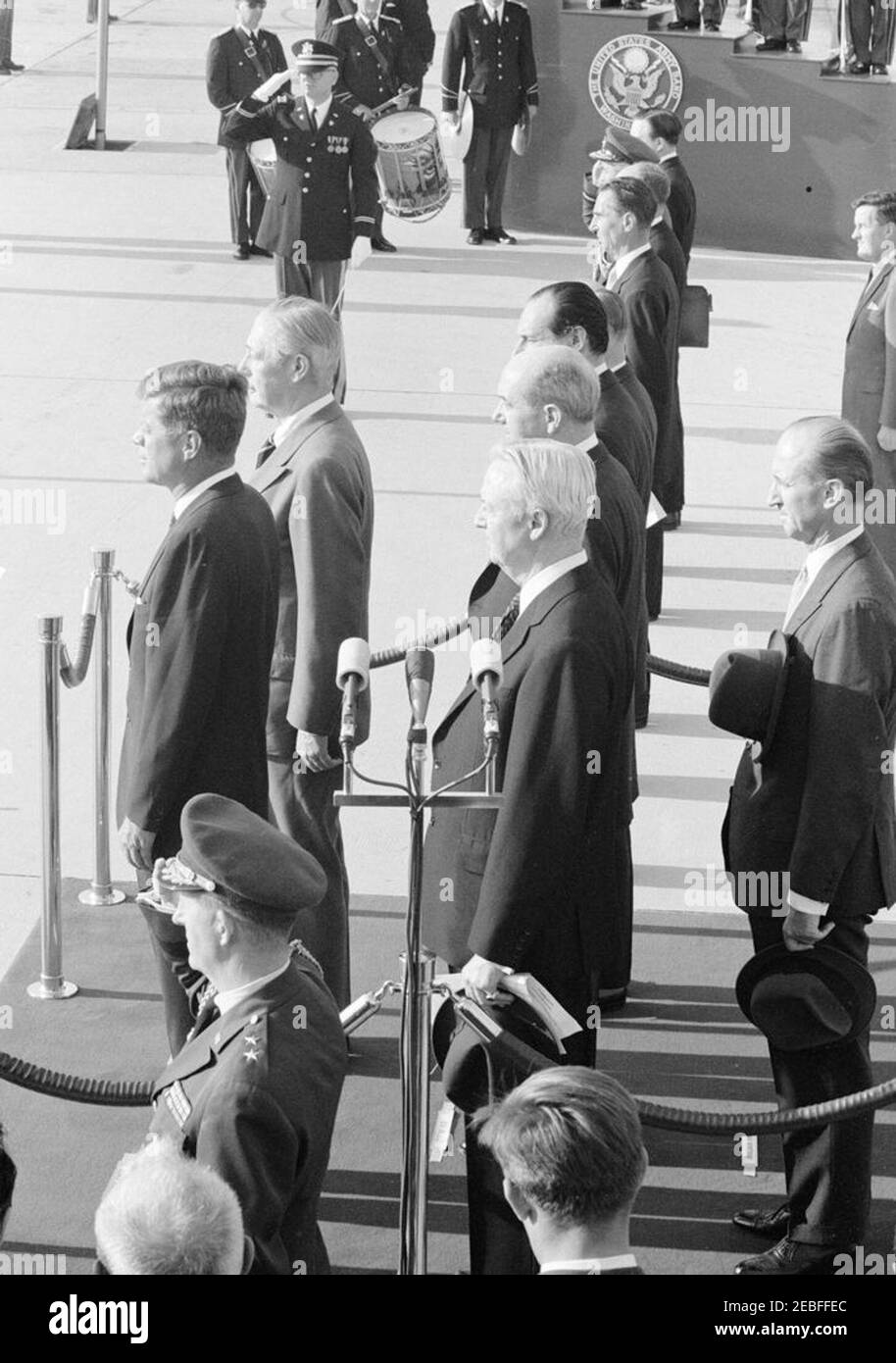 Cérémonies d'arrivée pour Harold Macmillan, Premier ministre de Grande-Bretagne, 4 h 50. Cérémonies d'arrivée en l'honneur du Premier ministre de Grande-Bretagne, Harold Macmillan. Debout sur la plate-forme d'examen (G-D): Le Président John F. Kennedy; le Premier ministre Macmillan; l'Ambassadeur des États-Unis en Grande-Bretagne, David K. E. Bruce; le Secrétaire d'État, Dean Rusk; l'Ambassadeur de Grande-Bretagne, Sir David Ormsby-Gore (partiellement caché); et le Chef du Protocole, Angier Biddle Duke. Debout en groupe à droite de l'Ambassadeur Ormsby-Gore (d'avant en arrière): Secrétaire du Cabinet des PMu2019s, Sir Norman Brook (surtout Banque D'Images