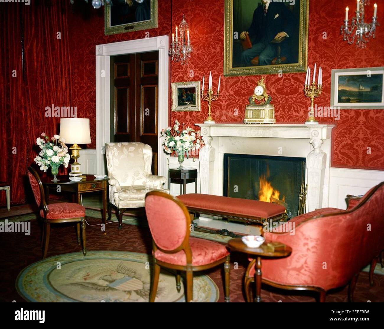 Salle à manger de l'État, salle de l'est, salle verte, salle bleue, salle rouge, tables et arrangements floraux pour dîner privé en l'honneur du prince et de la princesse Stanislaw Albrecht Radziwill. Salle rouge, avec arrangements floraux pour un dîner privé en l'honneur du prince Stanisu0142aw Albrecht (Stanislas Albert) Radziwiu0142u0142 de Pologne et de la princesse Lee Bouvier Radziwiu0142u0142. Une pièce de marbre (l'une d'une paire commandée après l'incendie de 1814, l'autre étant dans la salle verte); au-dessus de la pièce de menuiserie, porte un portrait de Woodrow Wilson. White House, Washington, D.C.rnrn Banque D'Images