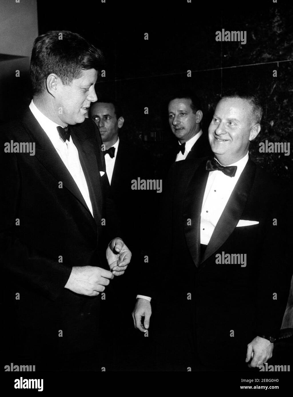 Dîner de l'Association des correspondants de la Maison Blanche, 7:30. Le président John F. Kennedy s'entretient avec les invités au dîner de l'Association à la Maison-Blanche au Sheraton Park Hotel, Washington, D.C. (L-R) le président Kennedy; l'acteur Joey Bishop; l'homme non identifié; le producteur du spectacle Joel Margolis Associationu0027s de la Maison-Blanche. Banque D'Images