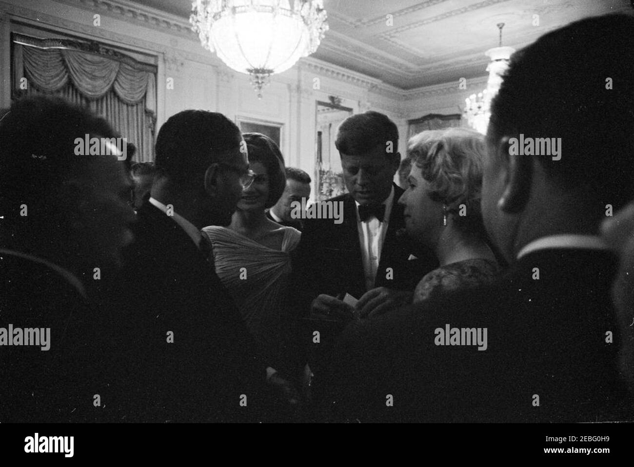 Dîner en l'honneur des lauréats du prix Nobel, 8:00. Le président John F. Kennedy et la première dame Jacqueline Kennedy visitent la salle East lors d'un dîner en l'honneur des lauréats du prix Nobel de l'hémisphère occidental. White House, Washington, D.C. Banque D'Images