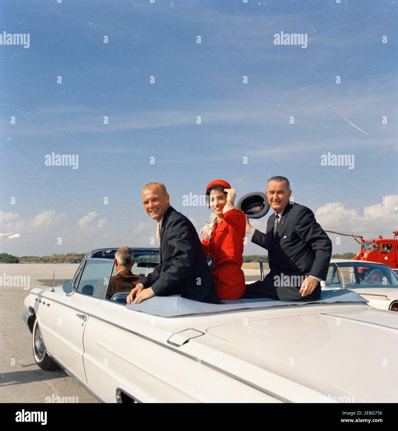 Remise de la Médaille du service distingué (DSM) de la NASA à l'astronaute John Herschel Glenn, Jr., à Cape Canaveral. Le lieutenant-colonel John H. Glenn, Jr. (À gauche), son épouse Annie Glenn, Et le vice-président Lyndon B. Johnson (à droite) s'assoient à l'arrière d'un cabriolet alors que leur cortège quitte la base aérienne de Patrick en route vers la station aérienne de Cape Canaveral pour la cérémonie de remise de la Médaille du service distingué de la National Aeronautics and Space Administration (NASA) au lieutenant-colonel Glenn. Comté de Brevard, Floride. Banque D'Images