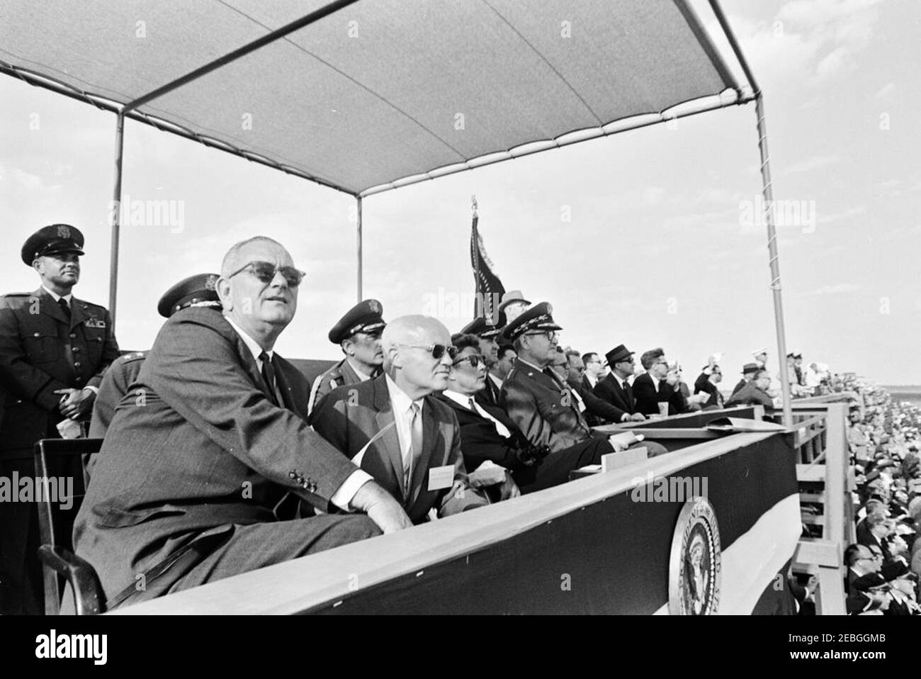 Voyage en Louisiane et en Floride : base aérienne d'Eglin, Floride, Air Proving Ground Center, démonstration de puissance de feu avec armes à feu, 13:15. Le président John F. Kennedy (au centre, portant des lunettes de soleil) observe une démonstration de puissance de feu d'armes habitée au Air Proving Ground Center, à la base aérienne d'Eglin, dans le comté d'Okaloosa, en Floride. Parmi les autres photos, mentionnons le vice-président Lyndon B. Johnson; l'aide de la Force aérienne au président, le général de brigade Godfrey T. McHugh; le secrétaire de la Force aérienne, Eugene M. Zuckert; le commandant du Centre de terrain d'essai aérien, le général de division Robert H. Warren; le chef d'état-major de l'Uni Banque D'Images
