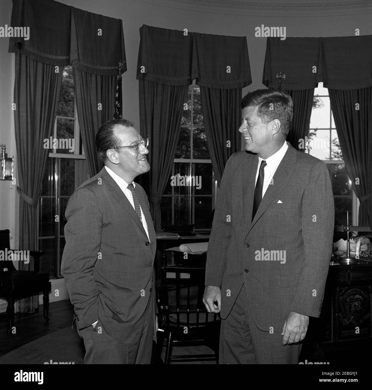 Visite des membres de la Commission de l'éducation politique (COPE) et de l'AFL-CIO (Fédération américaine du travail et Congrès des organisations industrielles), 5:45. Le Président John F. Kennedy se tient avec un homme non identifié (à gauche) lors d'une visite avec les délégués à une conférence sur l'inscription des électeurs parrainée par la Commission de l'éducation politique (COPE) de la Fédération américaine du travail et du Congrès des organisations industrielles (AFL-CIO). Oval Office, Maison Blanche, Washington, D.C. Banque D'Images