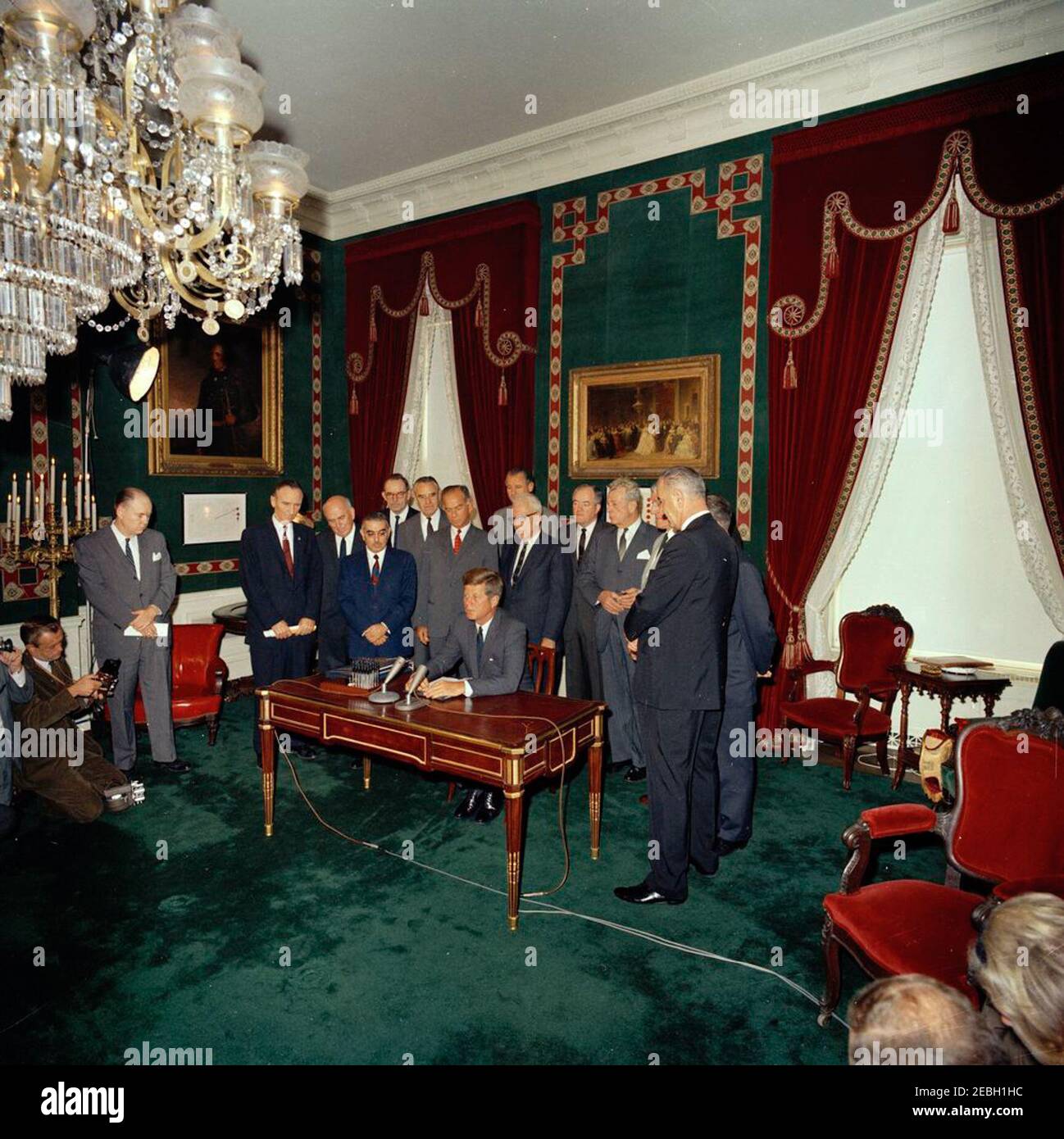 Cérémonie de signature, Traité d'interdiction des essais nucléaires, 10 h 00. Le président John F. Kennedy prononce un discours après la signature du Traité d'interdiction des essais nucléaires. Recherche sur (G-D): Photographe non identifié (à genoux); non identifié; sénateur Mike Mansfield (Montana); conseiller du Président sur le désarmement, John McCloy; sénateur John O. Pastore (Rhode Island); directeur adjoint de l'Agence de contrôle des armements et du désarmement (ACDA), Adrian S. Fisher; sous-secrétaire d'État aux Affaires politiques, W. Averell Harriman; Le sénateur J. William Fulbright (Arkansas); le sénateur George A. Smathers de la Floride (à l'arrière); le sénateur George D. ai Banque D'Images