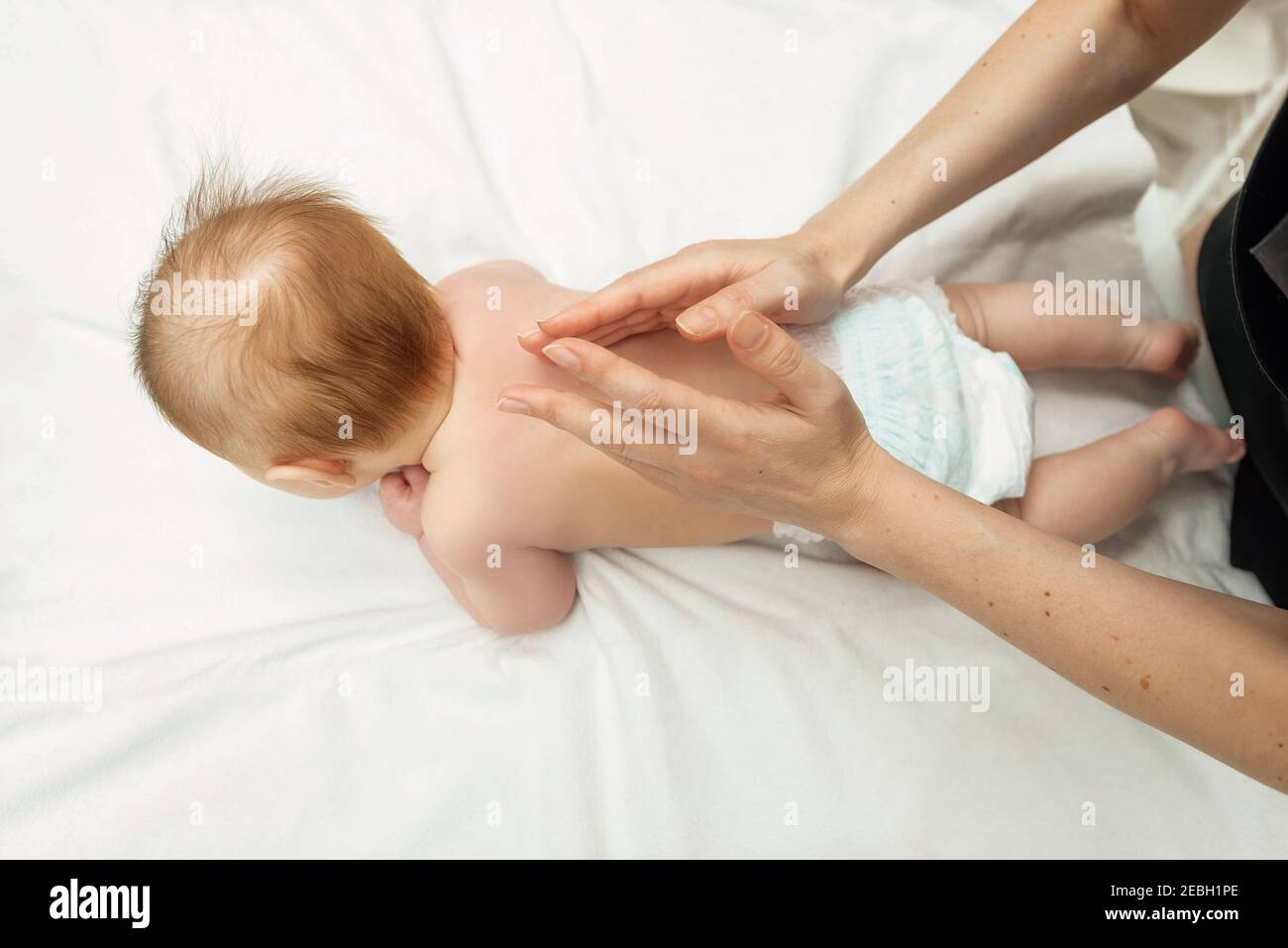 Jeune Mere Faisant Un Massage Sur Le Dos De Bebe Probleme De Sante Du Corps Concept De Massage Pour Bebe Bebe De 3 Mois Couche Sur Le Ventre Point De Vue Photo