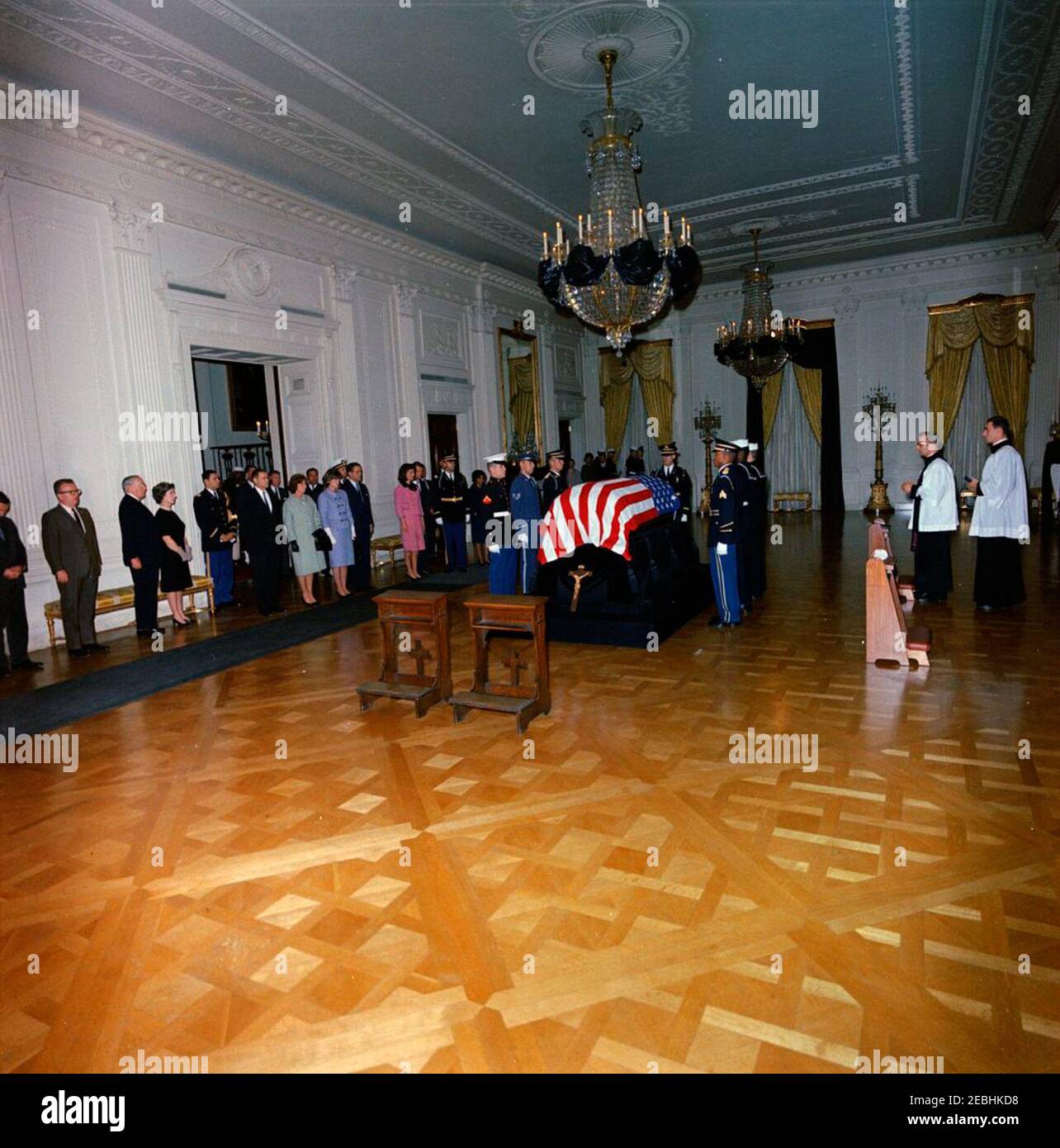Funérailles d'État du président Kennedy : couché en repos dans la salle est de la Maison Blanche. Feu le président John F. Kennedy se trouve en position de repos dans la salle de l'est ; le cercueil drapé par le drapeau du président Kennedyu2019s est au centre, après son arrivée à la Maison Blanche. Les amateurs observent; les membres de la garde d'honneur tiennent la montre. Les photos sont les suivantes : la première dame Jacqueline Kennedy; le procureur général, Robert F. Kennedy; Jean Kennedy Smith; Ethel Skakel Kennedy; le directeur du corps de la paix, R. Sargent Shriver; Janet Auchincloss; Hugh D. Auchincloss; le secrétaire à la Défense, Robert S. McNamara; Specia Banque D'Images