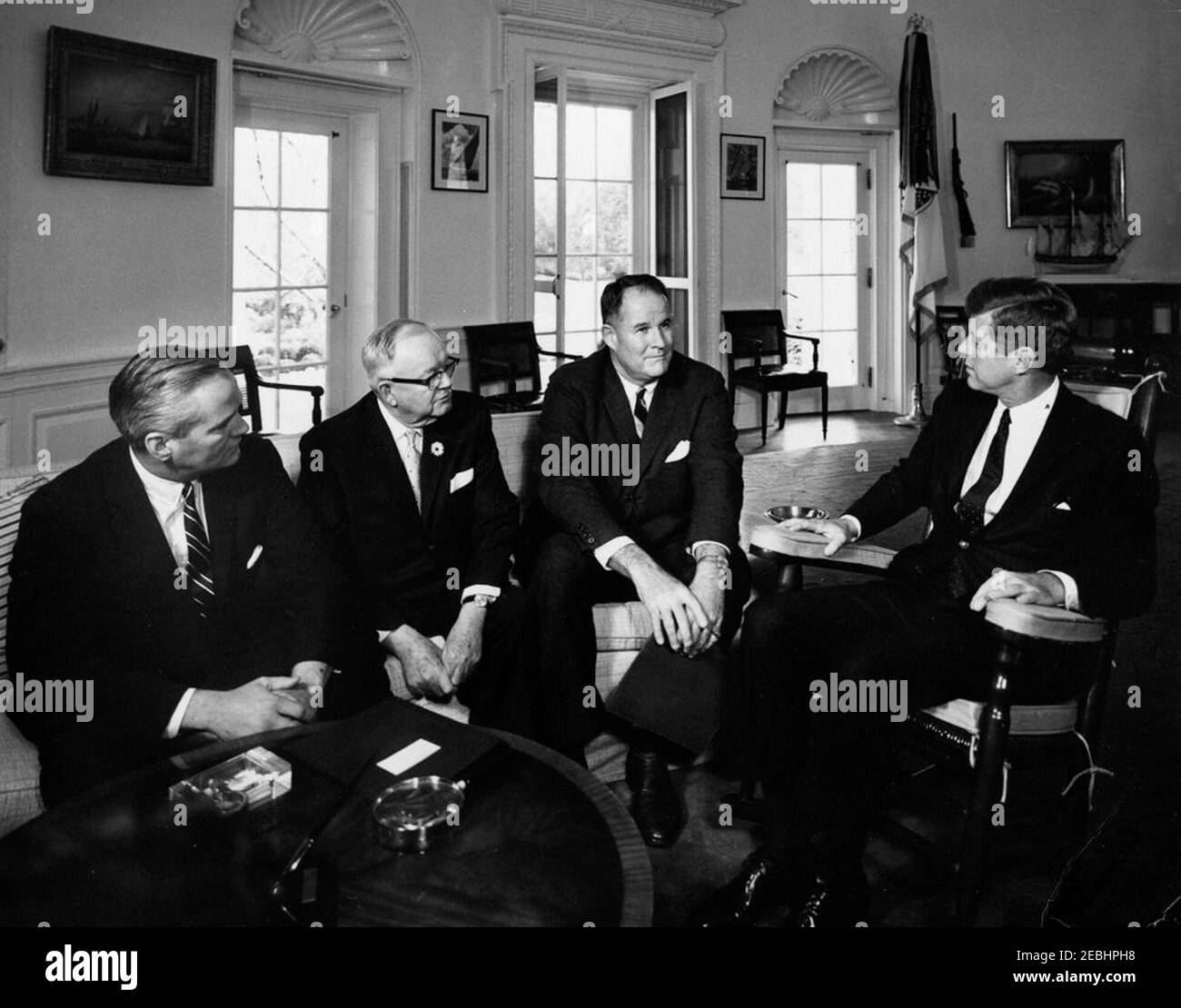 Présentation d'une invitation au Président Kennedy pour dédier l'autoroute à péage du Delaware/Maryland, 12:00. Le président John F. Kennedy (à droite, en fauteuil à bascule) accepte une invitation à participer aux cérémonies d'inauguration de l'autoroute à péage du Delaware-Maryland, le 14 novembre 1963. Assis sur le canapé (de gauche à droite): Sénateur Daniel B. Brewster du Maryland; gouverneur du Maryland, J. Millard Tawes; gouverneur du Delaware, Elbert N. Carvel. Oval Office, Maison Blanche, Washington, D.C. Banque D'Images