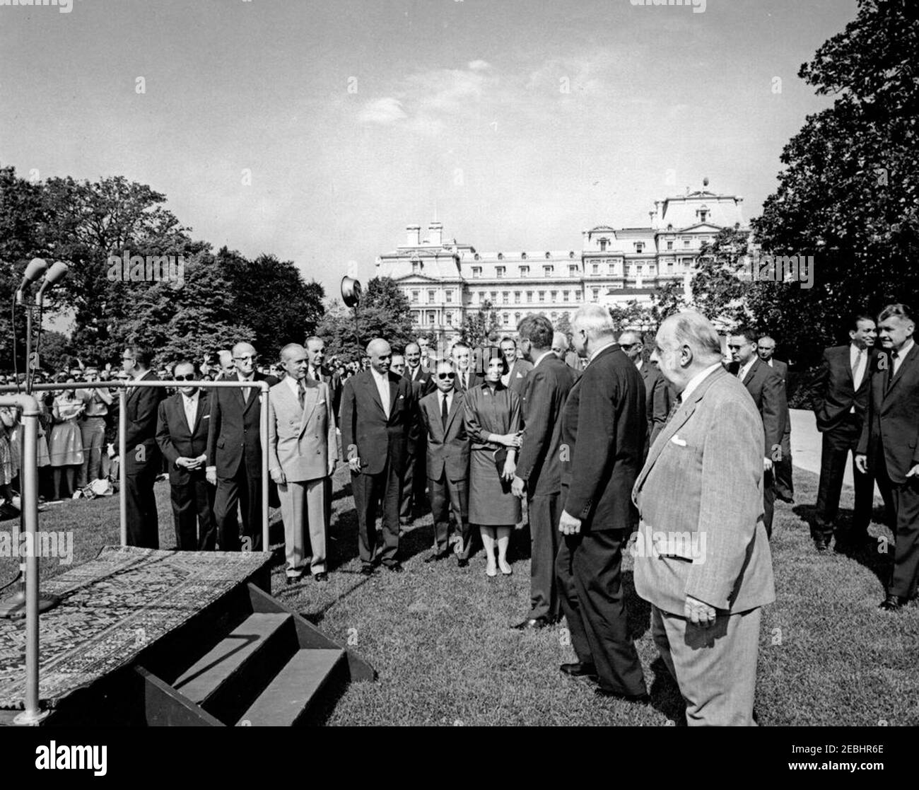 Visite des étudiants du service après-vente américain, 10:00. Le président John F. Kennedy (au centre à droite, en premier plan) se dirige vers la plate-forme Speakersu0027 avant de s'adresser à un groupe d'étudiants de l'American Field Service (AFS) réunis sur la pelouse sud de la Maison Blanche, Washington, D.C., sous-chef du protocole des États-Unis, William J. Tonesk, Et le directeur général de la AFS, Stephen Galatti, se promo derrière le président Kennedy. Debout à l'arrière (de gauche à droite): Bill Payne, agent du Service secret de la Maison Blanche; Omar Ong Yoke Lin, ambassadeur de Malaya; non identifié (à l'arrière, partiellement caché); Sir Ho, ambassadeur de l'Australie Banque D'Images