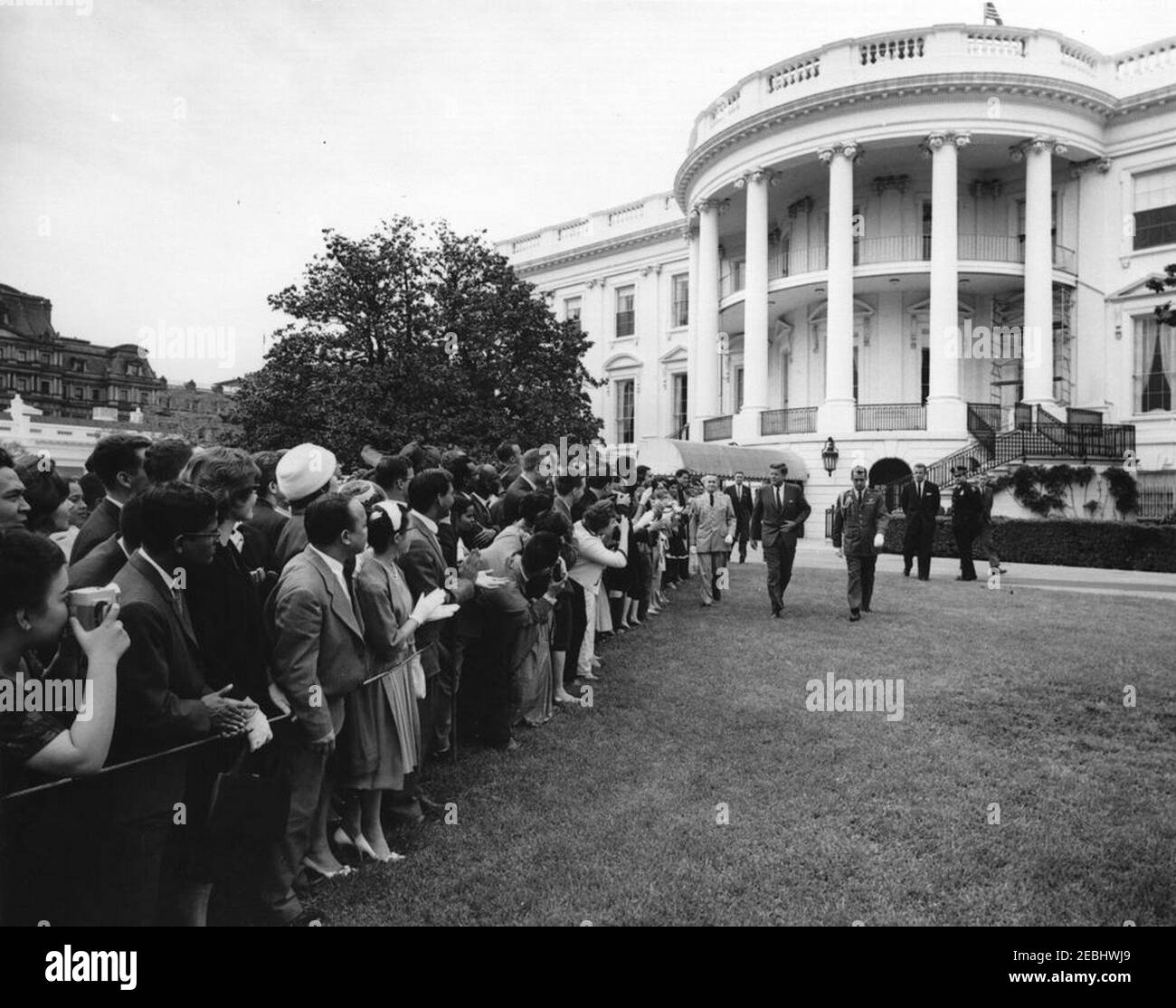 Réception pour étudiants étrangers, 3:55. Le Président John F. Kennedy assiste à une réception pour les étudiants étrangers sur la pelouse sud de la Maison Blanche, Washington, D.C. les invités incluent des étudiants des institutions suivantes de la région de Washington, D.C. : Université américaine, Université catholique d'Amérique, Collège Gallaudet, Université George Washington, Université Georgetown, Université Howard, École d'études internationales avancées de l'Université Johns Hopkins, Trinity College (Washington, D.C.), Université du Maryland et Collège Dunbarton de Sainte Croix. Également en photo : White House Secret Servi Banque D'Images