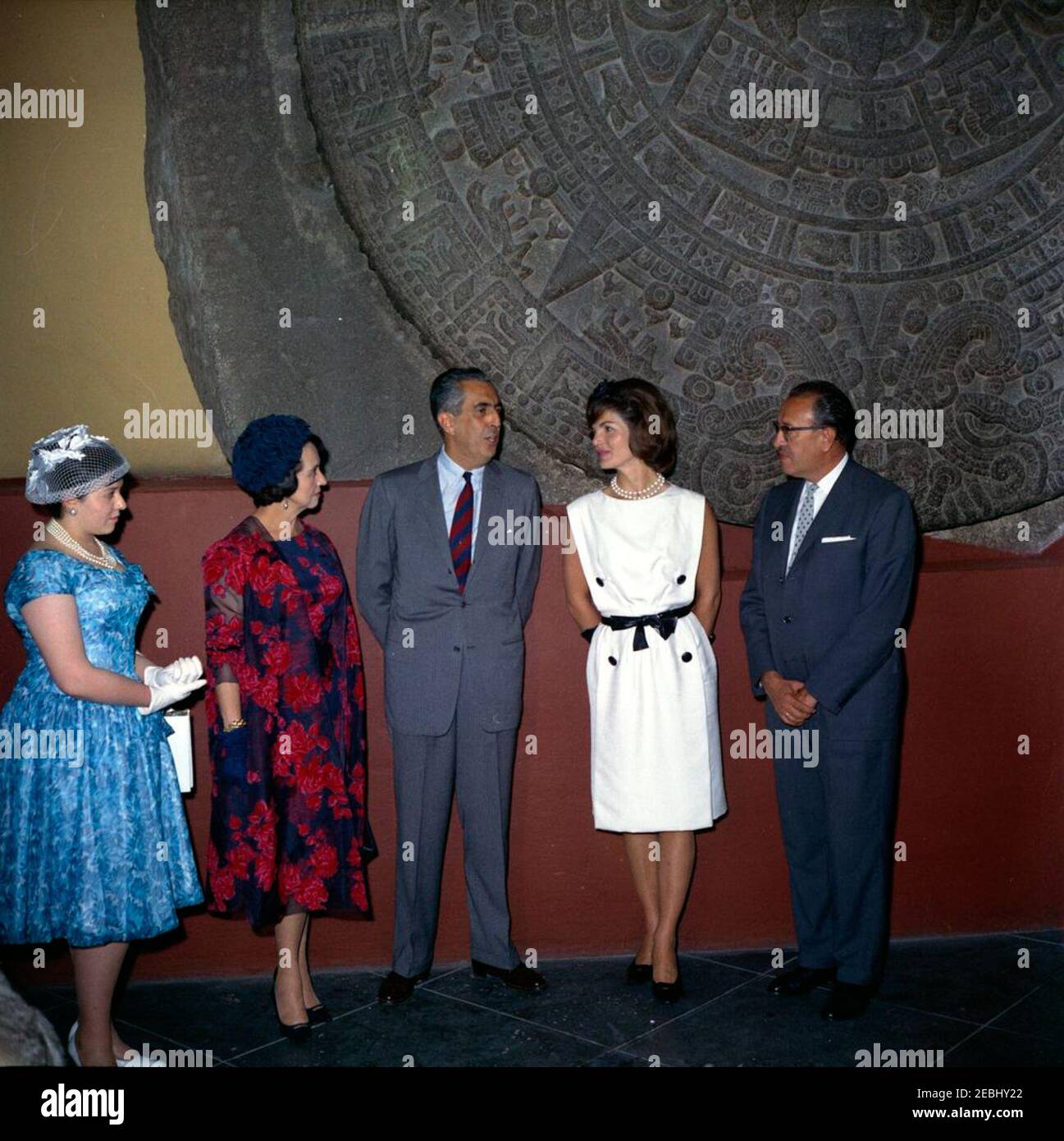 Voyage au Mexique : la première dame Jacqueline Kennedy (JBK) visite l'Institut national d'anthropologie u0026 Histoire. La première dame Jacqueline Kennedy se tient devant la Piedra del sol (calendrier aztèque, pierre du Soleil) lors d'une visite au Museo Nacional de Antropologu00eda (Musée national d'anthropologie) de l'Instituto Nacional de Antropologu00eda e Historia (Institut national d'anthropologie et d'histoire) à Mexico, au Mexique. De gauche à droite: EVA Lu00f3pez Mateos; première Dame du Mexique, Eva Su00e1mano de Lu00f3pez Mateos; sous-directrice de l'Instituto Nacional de Antropologu00eda e Historia Banque D'Images
