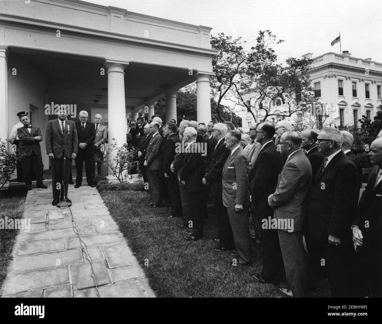 Visite des directeurs d'État du système de service sélectif, 9 h 55. Le président John F. Kennedy fait des remarques aux directeurs d'État du système de services sélectifs. Derrière le président Kennedy (G-D): Non identifié; Directeur national du Service sélectif, le Lieutenant-général Lewis B. Hershey; Président du Comité d'appel présidentiel du Service sélectif, James P. Ringley. Également en photo : correspondant de Washington pour la Guy Gannet Publishing Company of Maine, May Craig. West Wing Lawn, Maison Blanche, Washington, D.C. [Veuillez consulter le calendrier du Presidentu2019s pour une liste complète des participants Banque D'Images