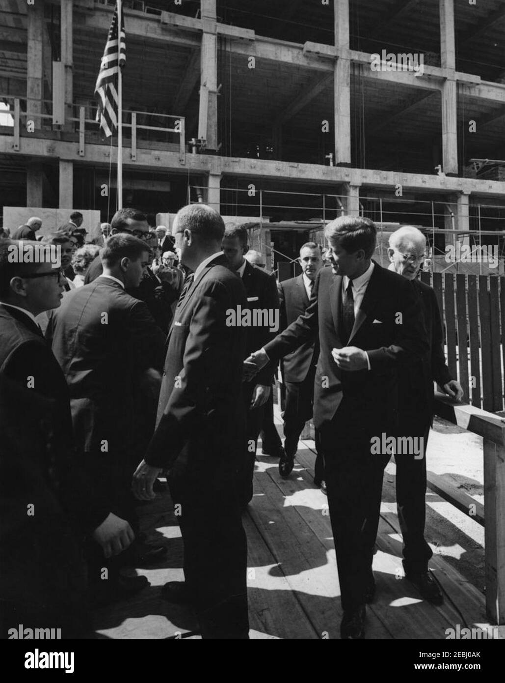 Cérémonie de pose de la pierre angulaire, immeuble Rayburn House, 10:28AM. Le président John F. Kennedy assiste à la cérémonie de pose des pierres angulaires de l'immeuble Rayburn House, dédié au regretté président de la Chambre des représentants, Sam Rayburn. Également en photo : Président de la Chambre et Président de la Commission de construction de bureaux de la Chambre, John W. McCormack (Massachusetts); agents du Service secret de la Maison Blanche, Ron Pontius et Lubert u201cBertu201d de Freese. Washington, D.C. Banque D'Images
