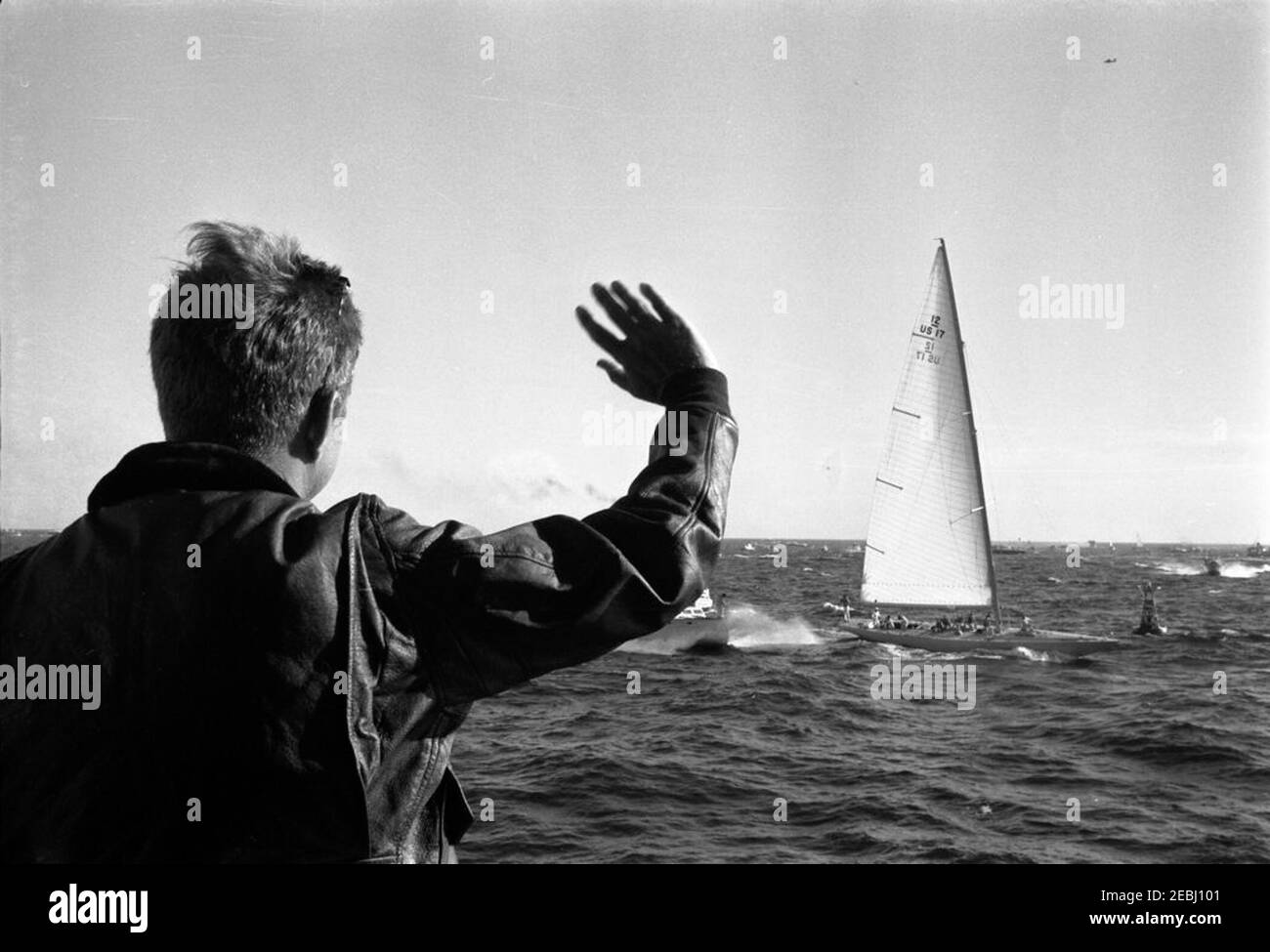 Le Président Kennedy Watches la 1ère course de la coupe Americau0027s. Le président John F. Kennedy se lance devant l'équipage du yacht, u201cWeatherlyu201d (du New York Yacht Club), tout en regardant la première course de la coupe Americau0027s 1962 à bord de l'USS Joseph P. Kennedy, Jr., au large de Newport, Rhode Island. Banque D'Images