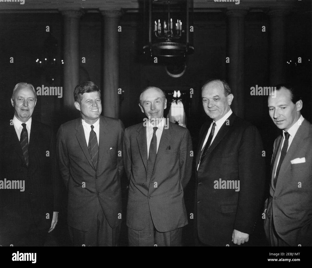 Déjeuner en l'honneur de Lord Alec Douglas-Home, secrétaire aux Affaires étrangères de la Grande-Bretagne, 13 h 00. Le président John F. Kennedy visite le secrétaire d'État aux Affaires étrangères de la Grande-Bretagne et le comte d'Home, Alec Douglas-Home; Lord Home visite la Maison Blanche pour assister à un déjeuner en son honneur. De gauche à droite : l'ambassadeur des États-Unis en Grande-Bretagne, David K. E. Bruce; le président Kennedy; Lord Home; le secrétaire d'État des États-Unis, Dean Rusk; l'ambassadeur de Grande-Bretagne, Sir David Ormsby-Gore. Hall d'entrée, Maison Blanche, Washington, D.C. Banque D'Images