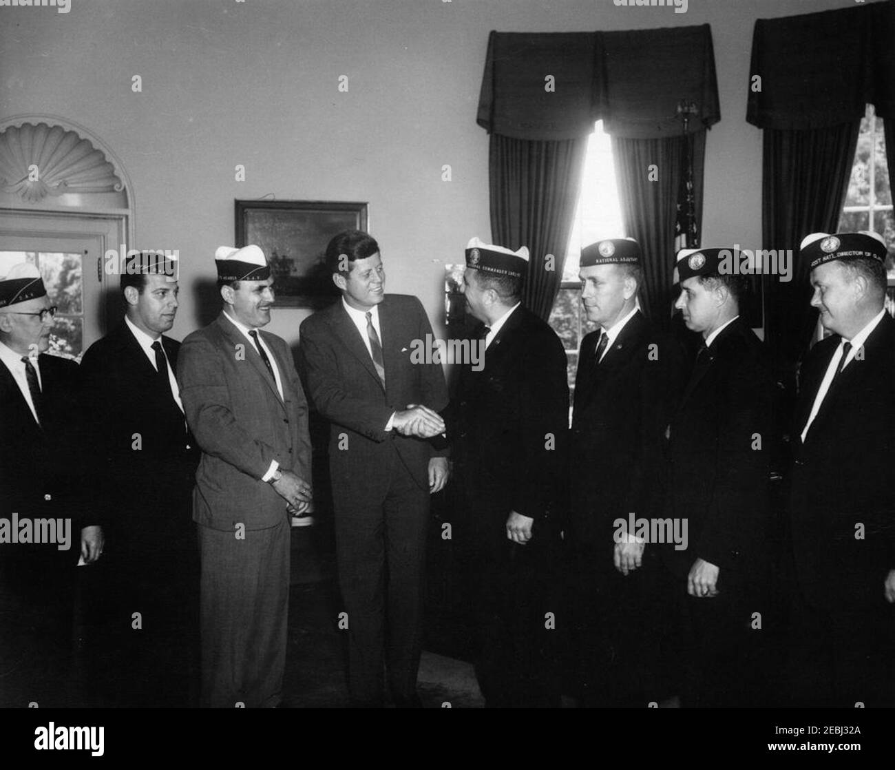 Visite des officiers des vétérans américains handicapés (DAV), 12:16. Le Président John F. Kennedy tremble la main avec le Commandant national des anciens combattants américains handicapés (DAV), Francis R. Buono, lors d'une visite avec des officiers du DAV. De gauche à droite : le directeur national de la législation, Elmer Freudenberger; le directeur adjoint du service national de l'emploi, Pasquale Gervace; le directeur du service national, Irving Peltz; le président Kennedy; le commandant national Buono (qui se mêle au président); l'Adjudant national, Denvel D. Adams; l'adjoint législatif du commandant national, Charles L. Huber; Assist Banque D'Images