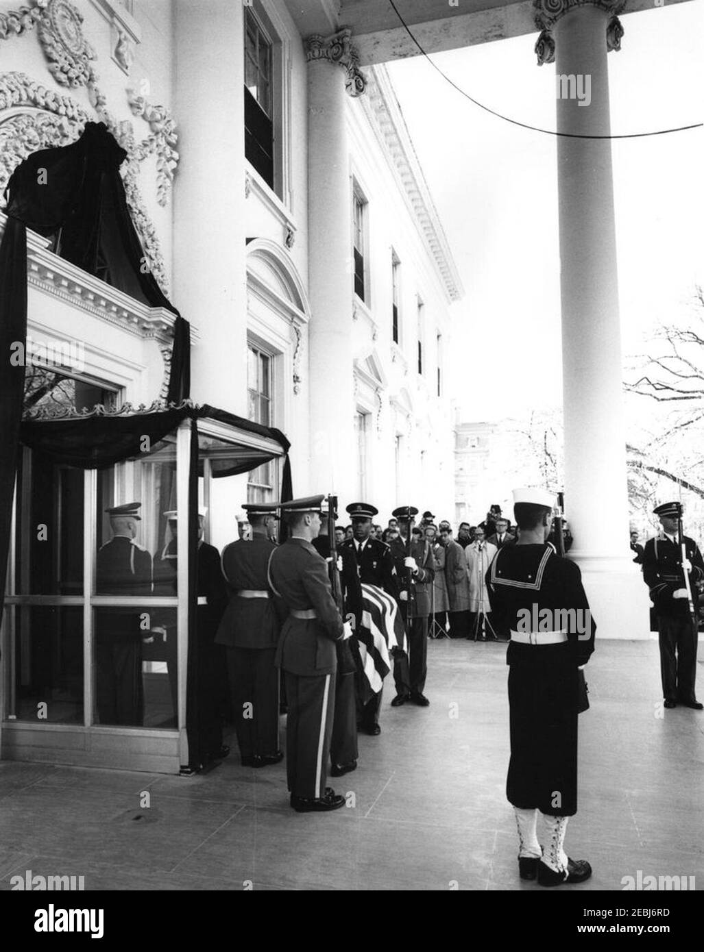 Funérailles d'État du président Kennedy : départ de la Maison Blanche et procession au Capitole des États-Unis. Les pallbarers de garde d'honneur portent le cercueil à pavillon du président John F. Kennedy par l'entrée nord de la Maison Blanche, avant une procession funéraire au Capitole. Les membres de la garde d'honneur sont à l'attention; les membres de la presse observent. Les pallbearers comprennent : le caporal Jerry J. Diamond (USMC), Yeoman George A. Barnum (USCG), le lieutenant Samuel R. Bird (É.-U. Army), le Matelot de 1re classe Hubert Clark (USN), le Sergent James L. Felder (U.S. Armée), caporal Timothy F. Chee Banque D'Images
