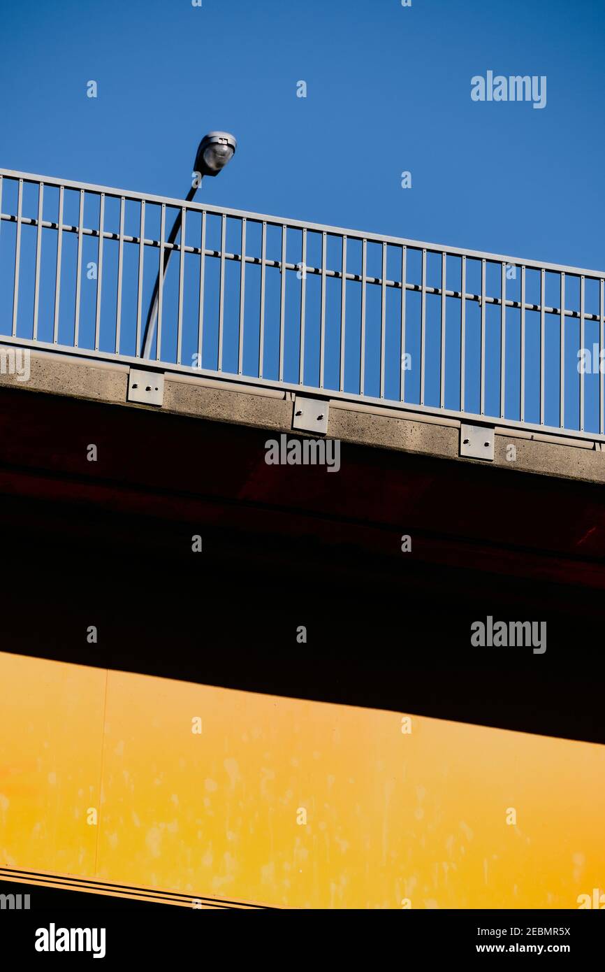 Gros plan vertical du pont routier peint en jaune sous ciel bleu clair. Banque D'Images