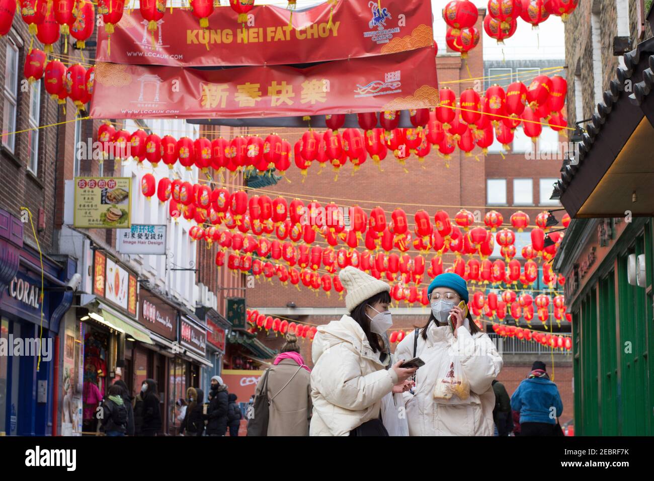 Londres, Royaume-Uni. 12 février 2021. Un couple portant des masques de protection contre la propagation de la covid-19 promenades le long de Gerrard Street pendant le nouvel an chinois.les célébrations du nouvel an chinois 2021 commence avec la nouvelle lune à Londres. Crédit : SOPA Images Limited/Alamy Live News Banque D'Images