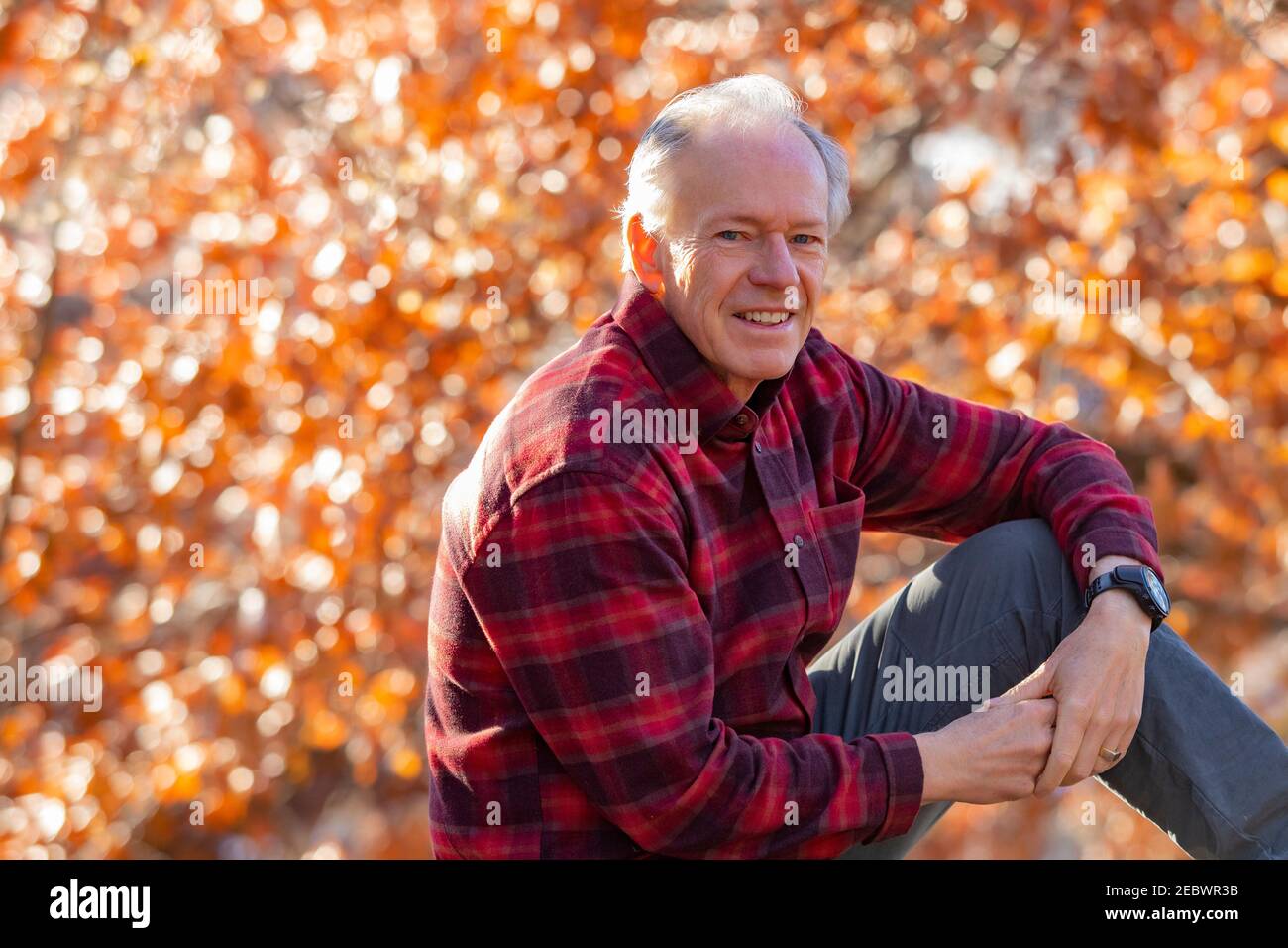 USA, Idaho, Boise, Portrait extérieur d'homme senior souriant assis à l'extérieur en automne Banque D'Images