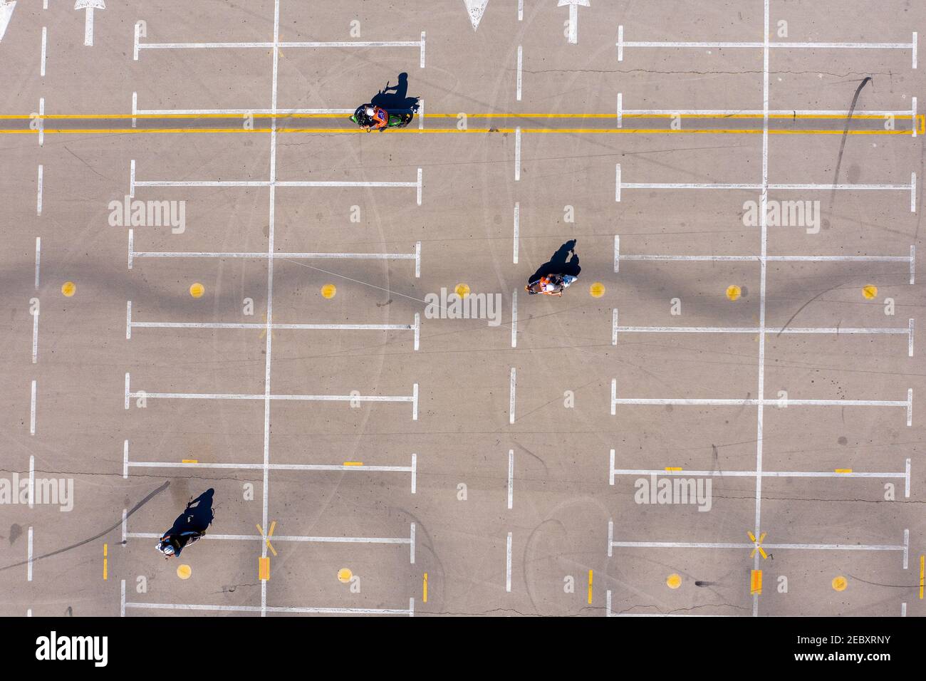 École de moto avec des cavaliers pratiquant la conduite lente et les slaloms, vue aérienne. Banque D'Images