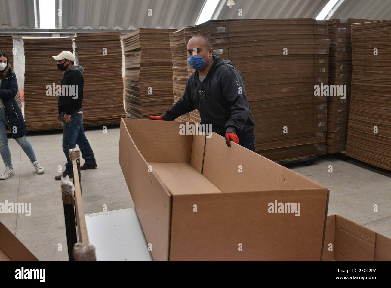 Un travailleur de l'usine de boîtes en carton KJ, pendant l'assemblage d'un  cercueil en carton. En raison de l'augmentation des décès de covid et de  l'augmentation du chômage dans le pays, l'usine