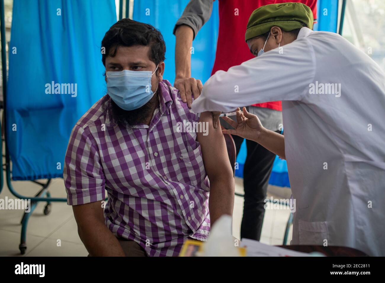 Une infirmière vaccine une femme avec le vaccin Covid 19 dans un hôpital de Dhaka, au Bangladesh Banque D'Images