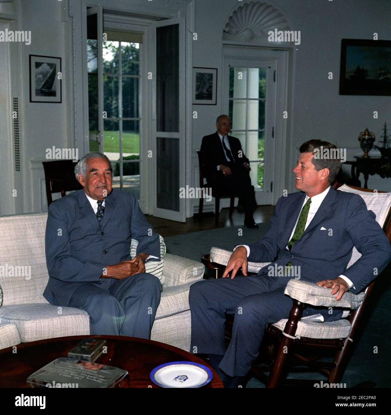 Rencontre avec Sir Alexander Bustamante, premier ministre de la Jamaïque, 10 h 04. Le Président John F. Kennedy (président à bascule) rencontre le Premier Ministre de la Jamaïque, Sir Alexander Bustamante. Le chef adjoint du Protocole, William J. Tonesk, est assis en arrière-plan. Oval Office, Maison Blanche, Washington, D.C. Banque D'Images
