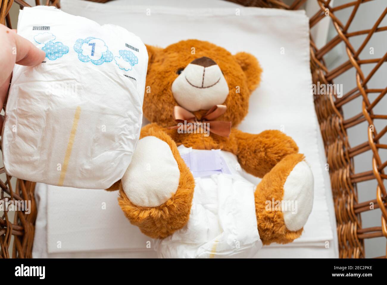 La Peinture D Un Ours En Peluche Brun Avec Couche Sur La Position Assise Dans Le Lit De Bebe Photo Stock Alamy