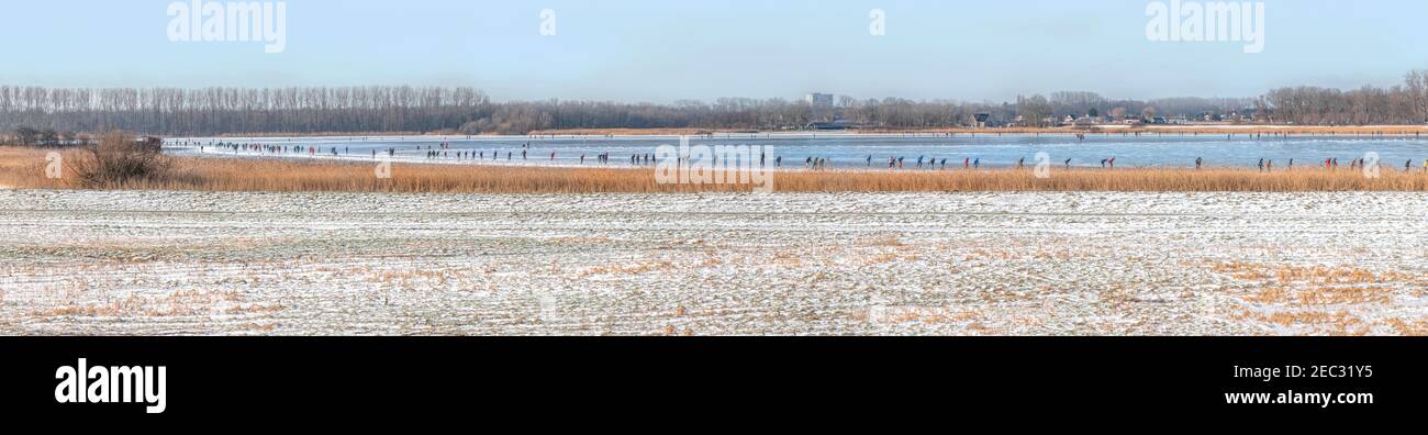 Vue panoramique des patineurs sur Vogelplas Starrevaart, un lac dans un polder à Leidschendam, dans le sud de la Hollande Banque D'Images