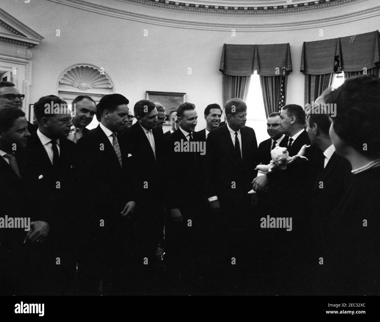 Visite des membres du Club politique de l'Académie évangélique de Bavière, Allemagne, 13:04. Des membres du Club politique de l'Académie évangélique (luthérienne) de Tutzing, en Bavière, en Allemagne (Evangelische Akademie Tutzing) présentent au Président John F. Kennedy une sculpture d'un chérubin. Les membres de l'Académie ne sont pas identifiés. Oval Office, Maison Blanche, Washington, D.C. [Voir aussi Mo 63.1907, u201cSculpture d'un Cherubu201d] Banque D'Images