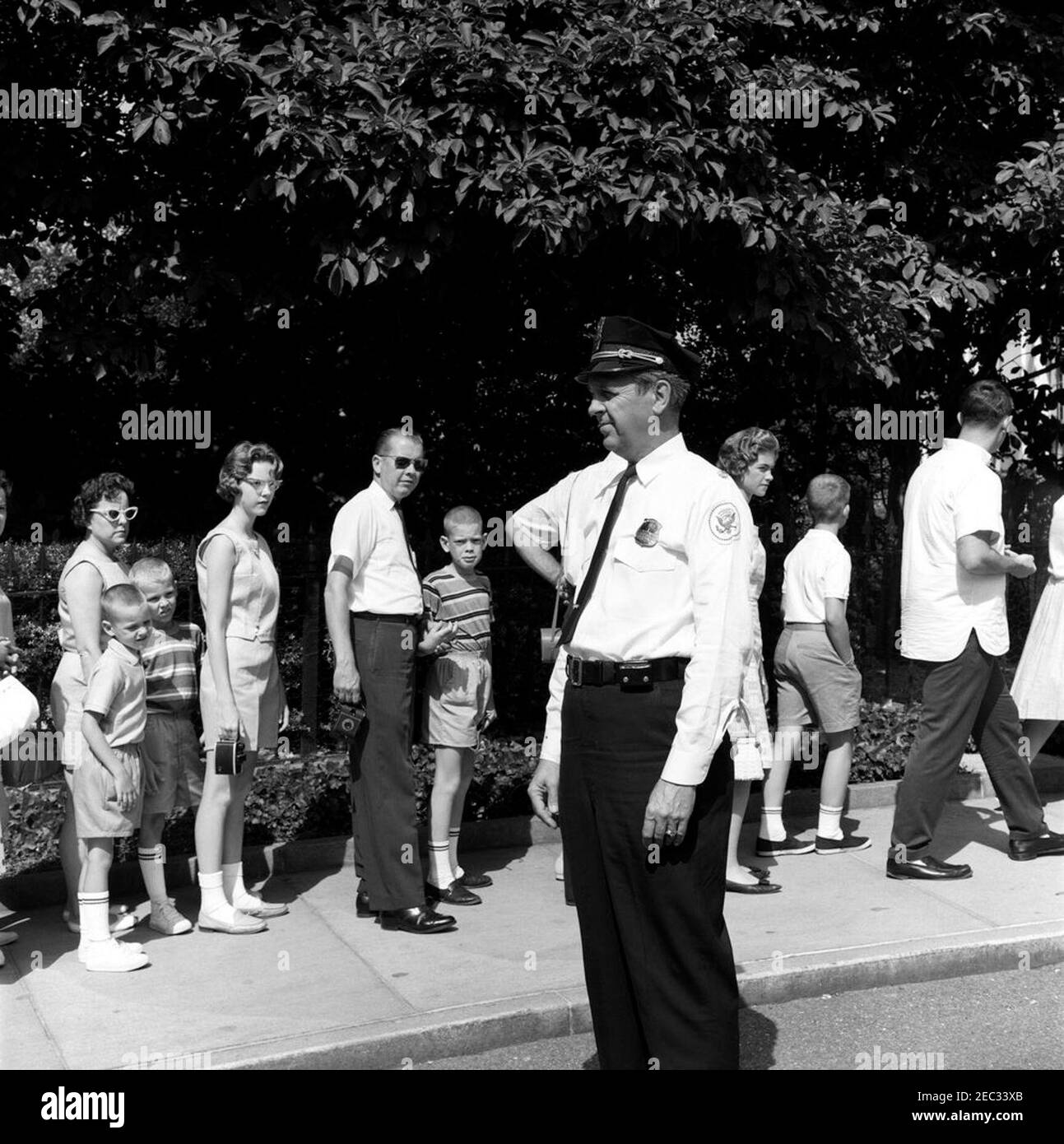 Chef de la police de la Maison Blanche, le major Ralph C. u0022Smokeyu0022 Stover, avec des visiteurs. Le chef de la police de la Maison Blanche, le major Ralph C. u0022Smokeyu0022 Stover, observe que les visiteurs attendent devant l'entrée du Visitoru2019s. Aile est, Maison Blanche, Washington, D.C. Banque D'Images