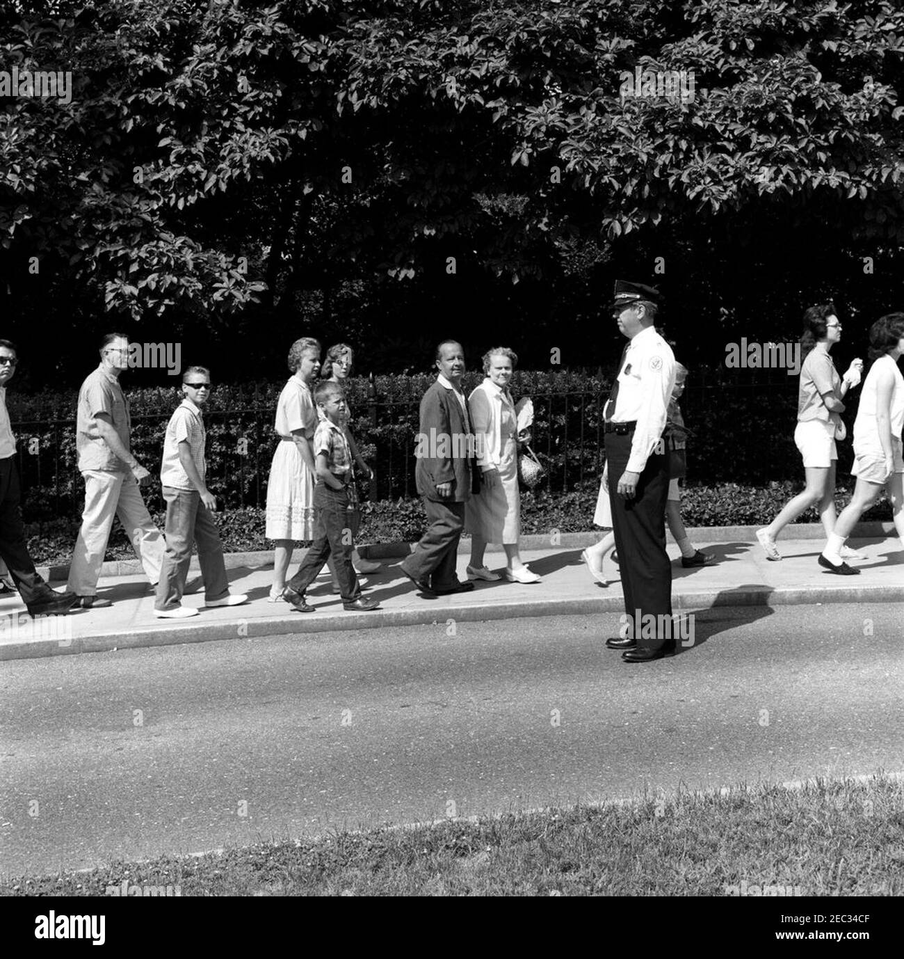 Chef de la police de la Maison Blanche, le major Ralph C. u0022Smokeyu0022 Stover, avec des visiteurs. Le chef de la police de la Maison Blanche, le major Ralph C. u0022Smokeyu0022 Stover, observe que les visiteurs attendent devant l'entrée du Visitoru2019s. Aile est, Maison Blanche, Washington, D.C. Banque D'Images