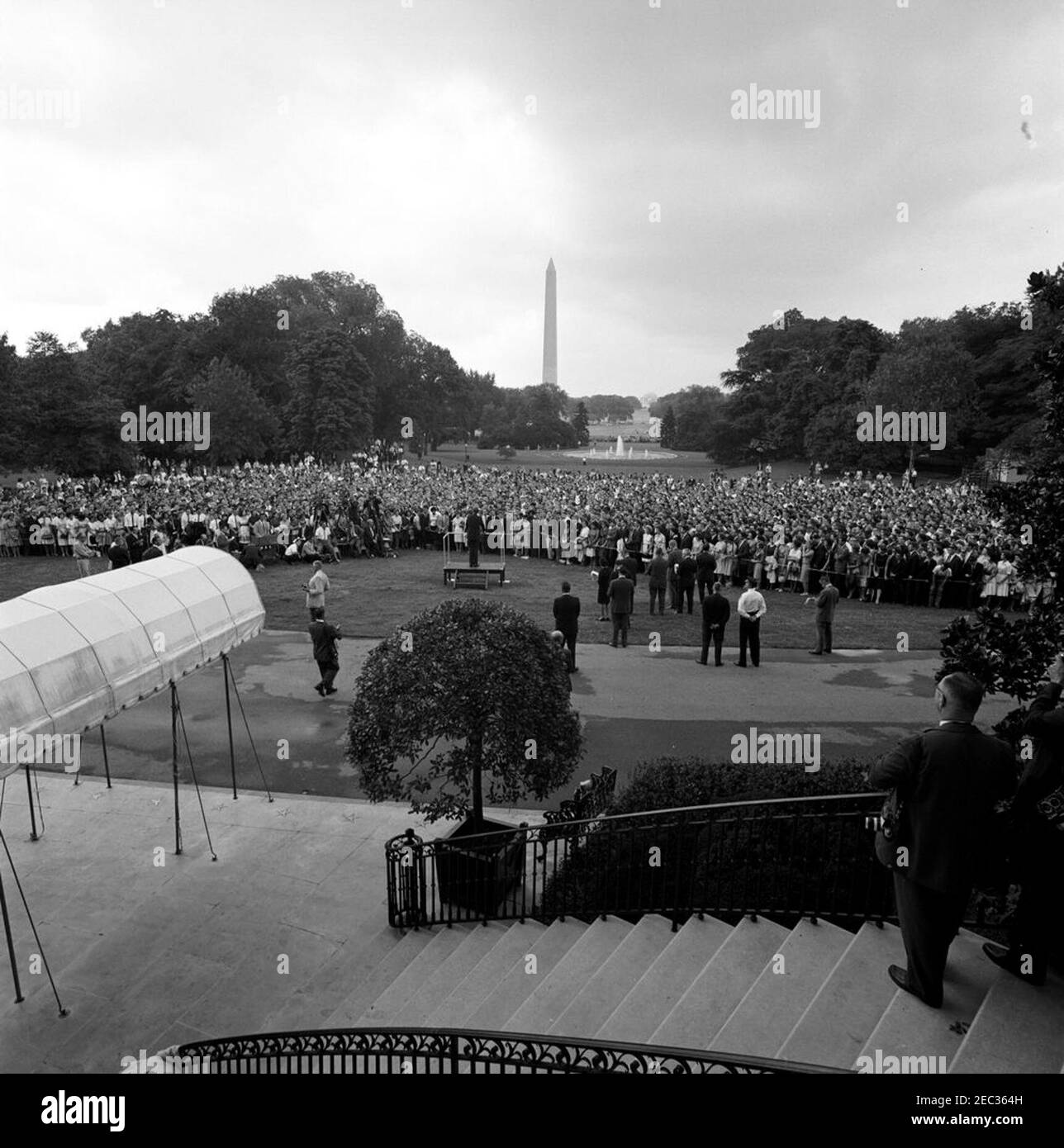 Visite des participants au séminaire de la Maison Blanche, 9 h 55. Le président John F. Kennedy (sur plateforme) prononce des discours d’adieu aux étudiants participant au séminaire d’été de la Maison Blanche. Également en photo : stagiaire au Bureau de presse de la Maison Blanche, Mimi Beardsley ; agent de l'Agence de communication de la Maison Blanche (WHCA), Oscar N. Smith ; électricien du réseau de médias de la Maison Blanche, Cleve Ryan ; photographe du National Park Service (NPS), Abbie Rowe ; correspondante de la Maison Blanche pour United Press International (UPI), Helen Thomas ; Correspondant de la Maison Blanche pour la National Broadcasting Company (NBC), Sander Vanocur; Maison Blanche Banque D'Images