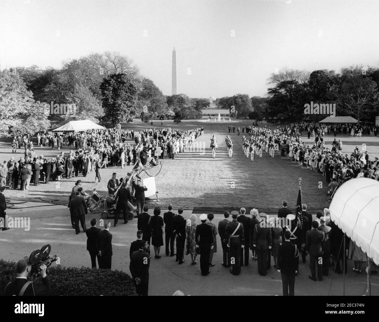 Le Président Kennedy salue les récipiendaires de la Médaille d'honneur du Congrès, réception militaire annuelle, 6 h 03. Vue de la pelouse sud de la Maison Blanche, comme l'Old Guard Fife and Drum corps, 1er Bataillon, 3e Régiment d'infanterie, se produit lors d'une réception militaire en l'honneur des récipiendaires de la Médaille d'honneur du Congrès. Le président John F. Kennedy et d'autres regardent les débats du Portico du Sud (à droite, au premier plan). Le Washington Monument et le Jefferson Memorial sont visibles au loin. Washington, D.C. Banque D'Images