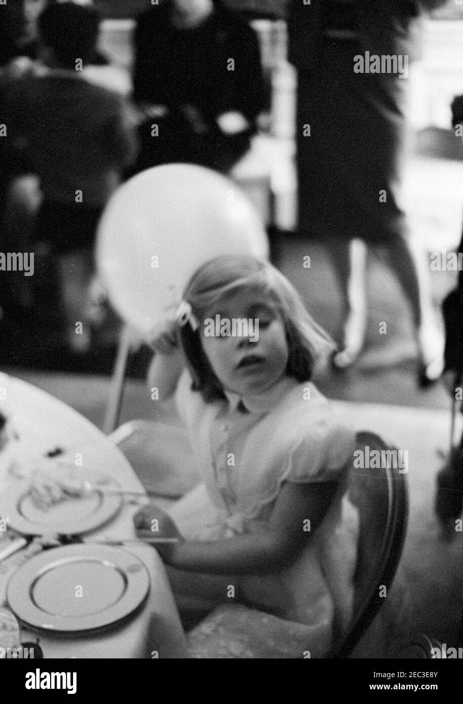 Fête d'anniversaire pour Caroline Kennedy et John F. Kennedy, Jr. Caroline Kennedy (avec un ballon) est assise à une table dans la Presidentu2019s Dining Room (Résidence) de la Maison Blanche, Washington, D.C., lors d'une fête d'anniversaire conjointe pour elle et son frère, John F. Kennedy, Jr. [Les rayures sur l'image sont originales au négatif.] Banque D'Images