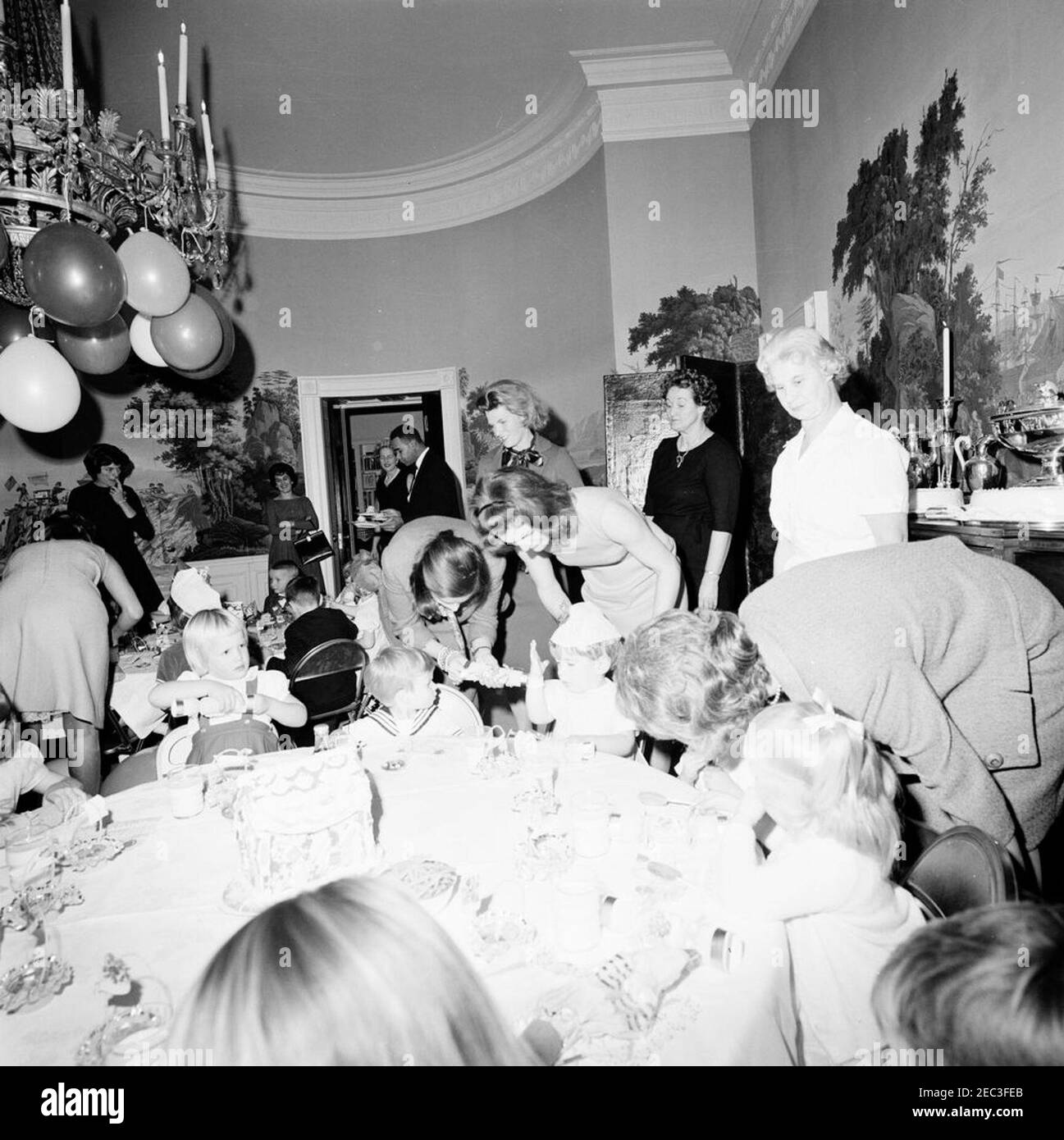 Fête d'anniversaire pour Caroline Kennedy et John F. Kennedy, Jr. John F. Kennedy, Jr. (Au centre à droite), est assis à une table dans la salle à manger du Presidentu2019s (résidence) de la Maison Blanche, Washington, D.C., lors d'une fête d'anniversaire conjointe pour lui et sa sœur, Caroline Kennedy; la première dame Jacqueline Kennedy se tient derrière son fils. Également en photo : Eunice Kennedy Shriver; première secrétaire sociale Ladyu0027s, Letitia Baldrige; maître d'hôtel de la Maison Blanche, Johnny Johnson. Banque D'Images Fête d'anniversaire pour Caroline Kennedy et John F. Kennedy, Jr. John F. Kennedy, Jr. (Au centre à droite), est assis à une table dans la salle à manger du Presidentu2019s (résidence) de la Maison Blanche, Washington, D.C., lors d'une fête d'anniversaire conjointe pour lui et sa sœur, Caroline Kennedy; la première dame Jacqueline Kennedy se tient derrière son fils. Également en photo : Eunice Kennedy Shriver; première secrétaire sociale Ladyu0027s, Letitia Baldrige; maître d'hôtel de la Maison Blanche, Johnny Johnson. Banque D'Images