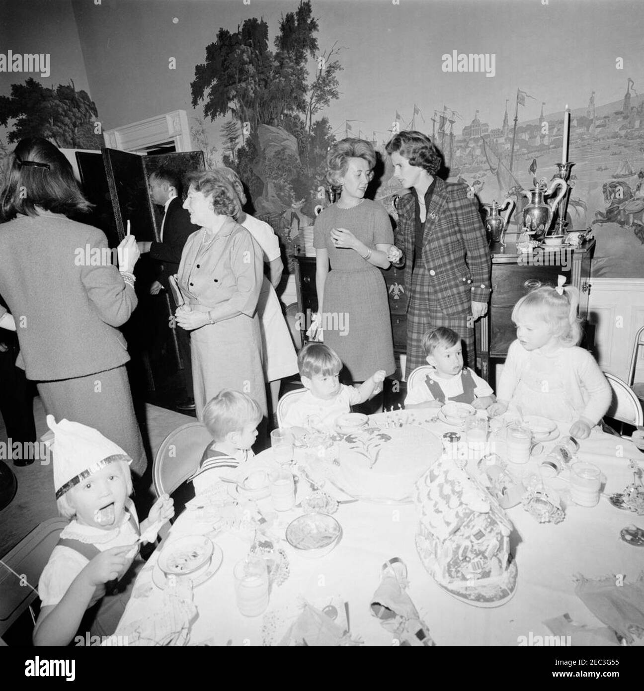 Fête d'anniversaire pour Caroline Kennedy et John F. Kennedy, Jr. John F. Kennedy, Jr. (Au centre, assis à la table), mange de la glace lors d'une fête d'anniversaire conjointe pour lui et sa sœur, Caroline Kennedy; John, Jr. SuP0027s Cake est assis sur la table devant lui. Aussi en photo : nounou aux enfants Kennedy, Maud Shaw; maître d'hôtel de la Maison Blanche, Eugene Allen. Presidentu2019s Dining Room (Residence), Maison Blanche, Washington, D.C. Banque D'Images Fête d'anniversaire pour Caroline Kennedy et John F. Kennedy, Jr. John F. Kennedy, Jr. (Au centre, assis à la table), mange de la glace lors d'une fête d'anniversaire conjointe pour lui et sa sœur, Caroline Kennedy; John, Jr. SuP0027s Cake est assis sur la table devant lui. Aussi en photo : nounou aux enfants Kennedy, Maud Shaw; maître d'hôtel de la Maison Blanche, Eugene Allen. Presidentu2019s Dining Room (Residence), Maison Blanche, Washington, D.C. Banque D'Images