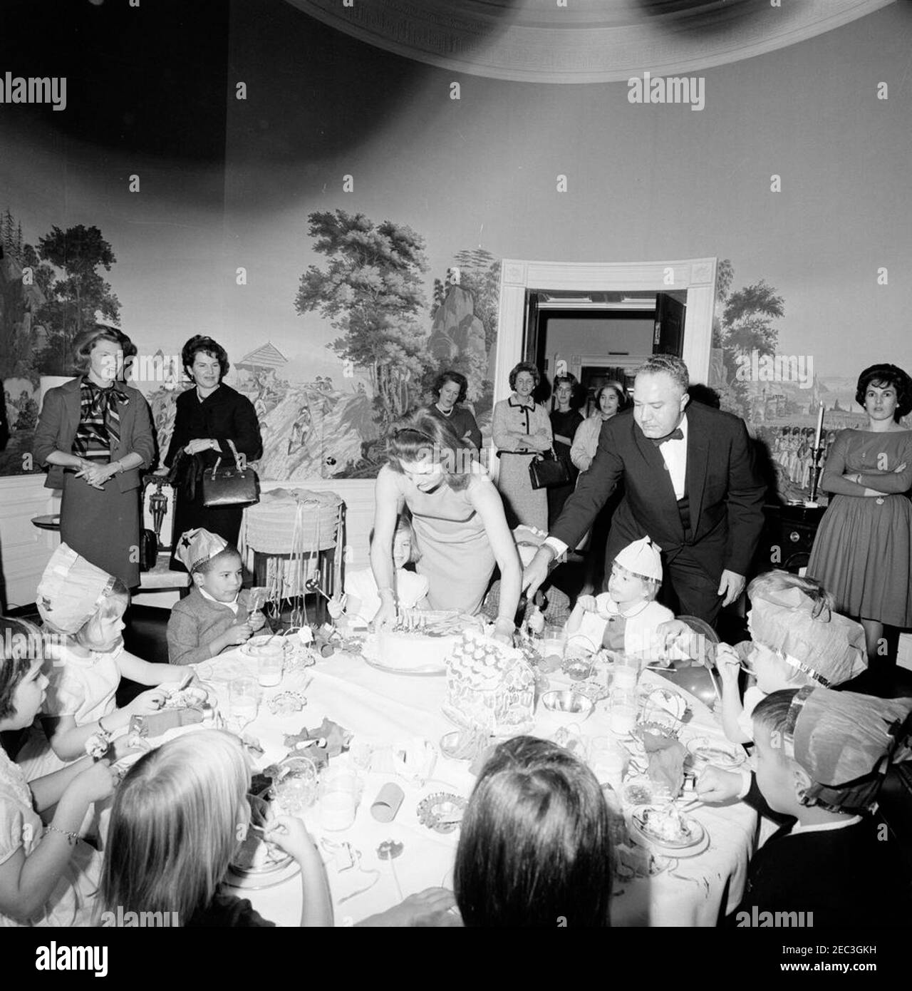 Fête d'anniversaire pour Caroline Kennedy et John F. Kennedy, Jr. La première dame Jacqueline Kennedy place Caroline Kennedyu0027s gâteau sur la table lors d'une fête d'anniversaire conjointe pour Caroline et John F. Kennedy, Jr. Avery Hatcher, fils du secrétaire de presse associé, Andrew T. Hatcher, est à gauche de Caroline; le maître d'hôtel de la Maison Blanche, John W. Ficklin, est à droite. Presidentu2019s Dining Room (Residence), Maison Blanche, Washington, D.C. Banque D'Images Fête d'anniversaire pour Caroline Kennedy et John F. Kennedy, Jr. La première dame Jacqueline Kennedy place Caroline Kennedyu0027s gâteau sur la table lors d'une fête d'anniversaire conjointe pour Caroline et John F. Kennedy, Jr. Avery Hatcher, fils du secrétaire de presse associé, Andrew T. Hatcher, est à gauche de Caroline; le maître d'hôtel de la Maison Blanche, John W. Ficklin, est à droite. Presidentu2019s Dining Room (Residence), Maison Blanche, Washington, D.C. Banque D'Images