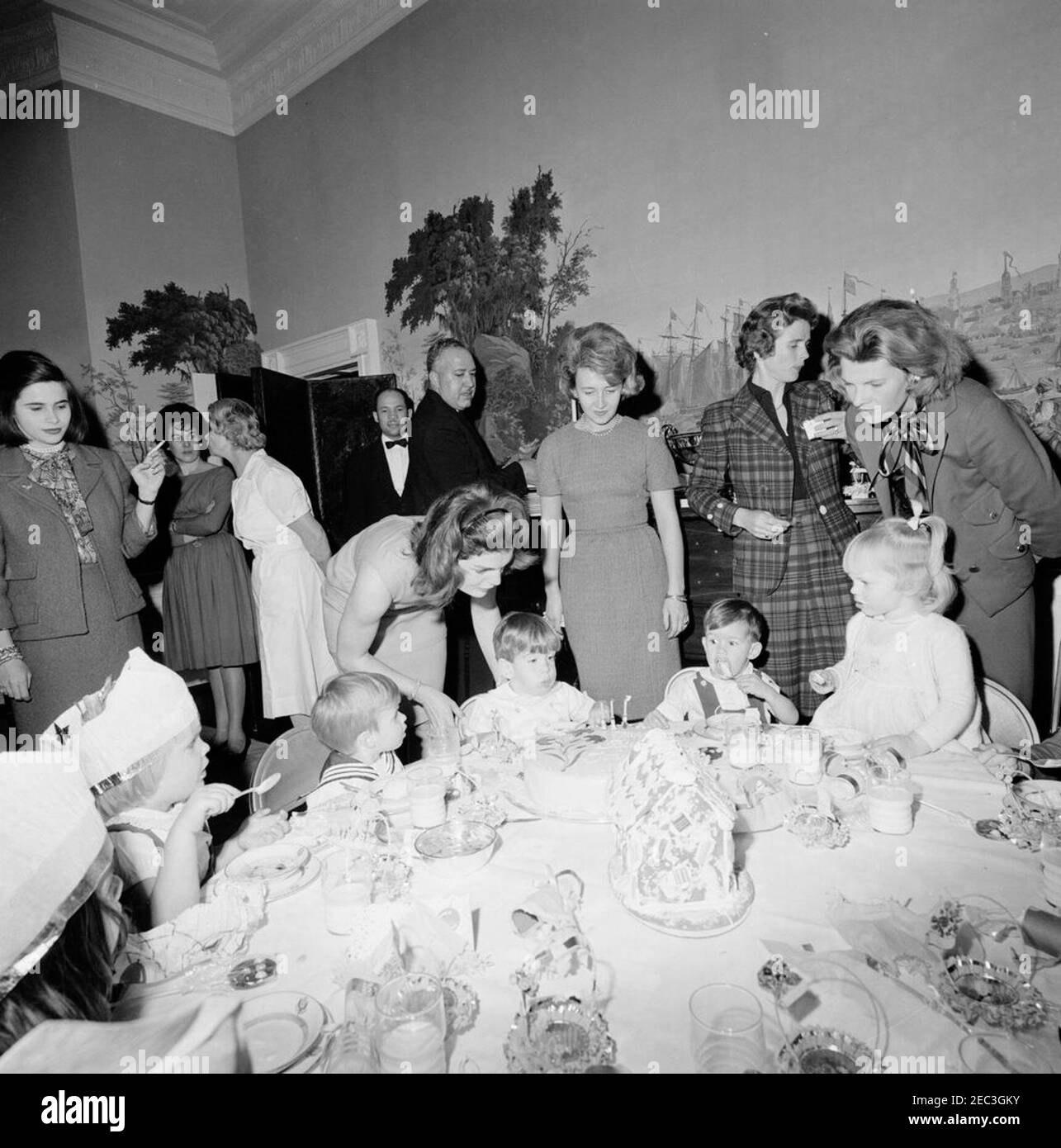 Fête d'anniversaire pour Caroline Kennedy et John F. Kennedy, Jr. John F. Kennedy, Jr., souffle les bougies sur son gâteau lors d'une fête d'anniversaire conjointe pour lui et sa sœur, Caroline Kennedy; la première dame Jacqueline Kennedy se tient derrière son fils. Également en photo : les majordomes de la Maison Blanche, Eugene Allen et John W. Ficklin. Presidentu2019s Dining Room (Residence), Maison Blanche, Washington, D.C. Banque D'Images Fête d'anniversaire pour Caroline Kennedy et John F. Kennedy, Jr. John F. Kennedy, Jr., souffle les bougies sur son gâteau lors d'une fête d'anniversaire conjointe pour lui et sa sœur, Caroline Kennedy; la première dame Jacqueline Kennedy se tient derrière son fils. Également en photo : les majordomes de la Maison Blanche, Eugene Allen et John W. Ficklin. Presidentu2019s Dining Room (Residence), Maison Blanche, Washington, D.C. Banque D'Images